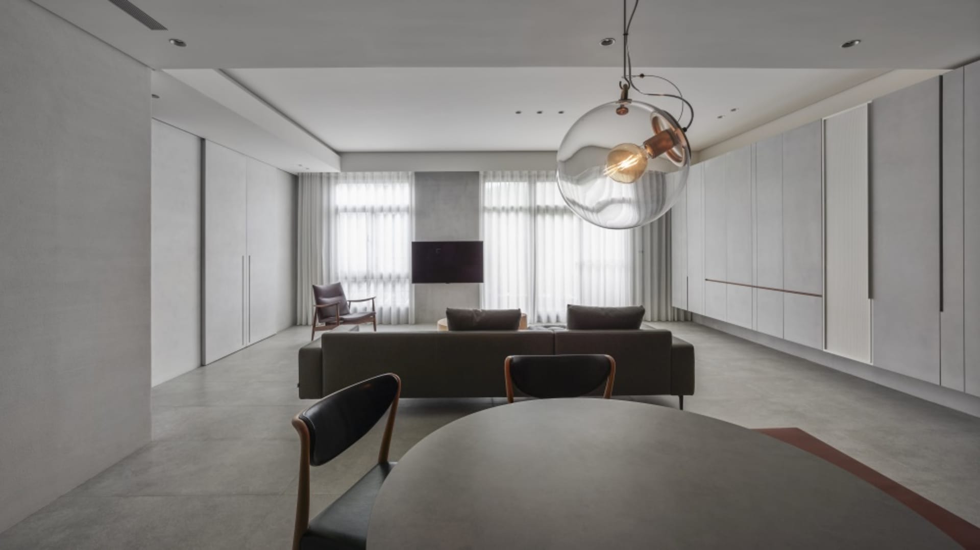 Modern living room with concrete floors and a minimalist design.