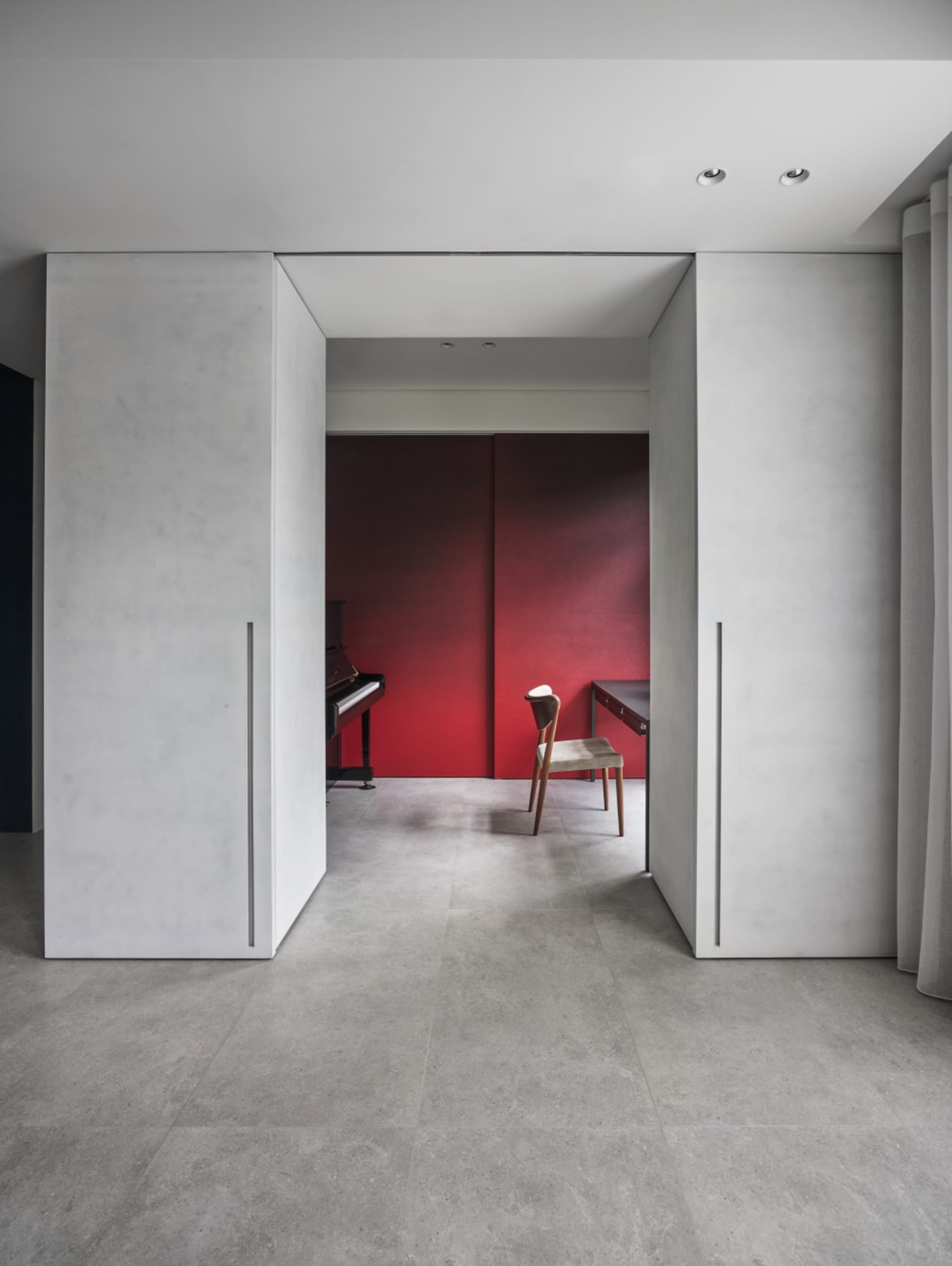 An image of a modern office space with a minimalist design, featuring a desk, chair, and a piano.
