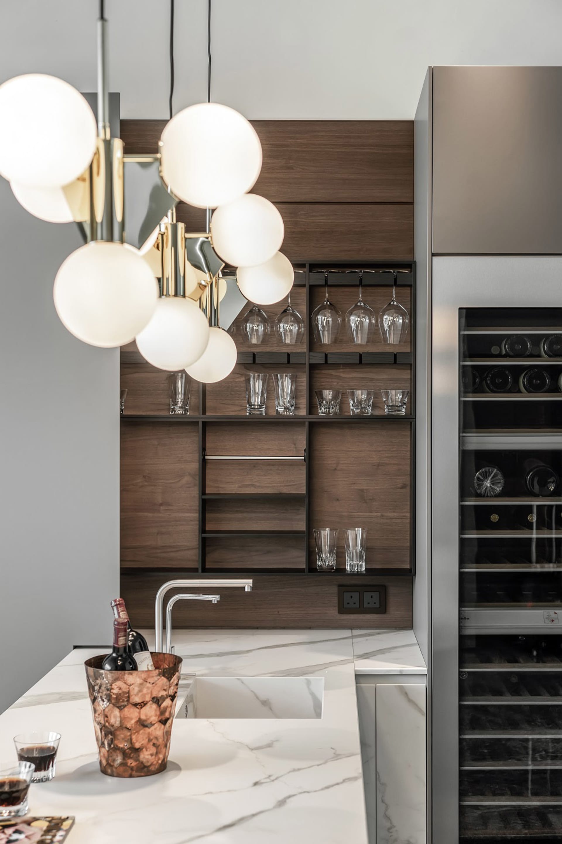 Modern kitchen with white marble countertops, black wood accents, and a built-in appliance.