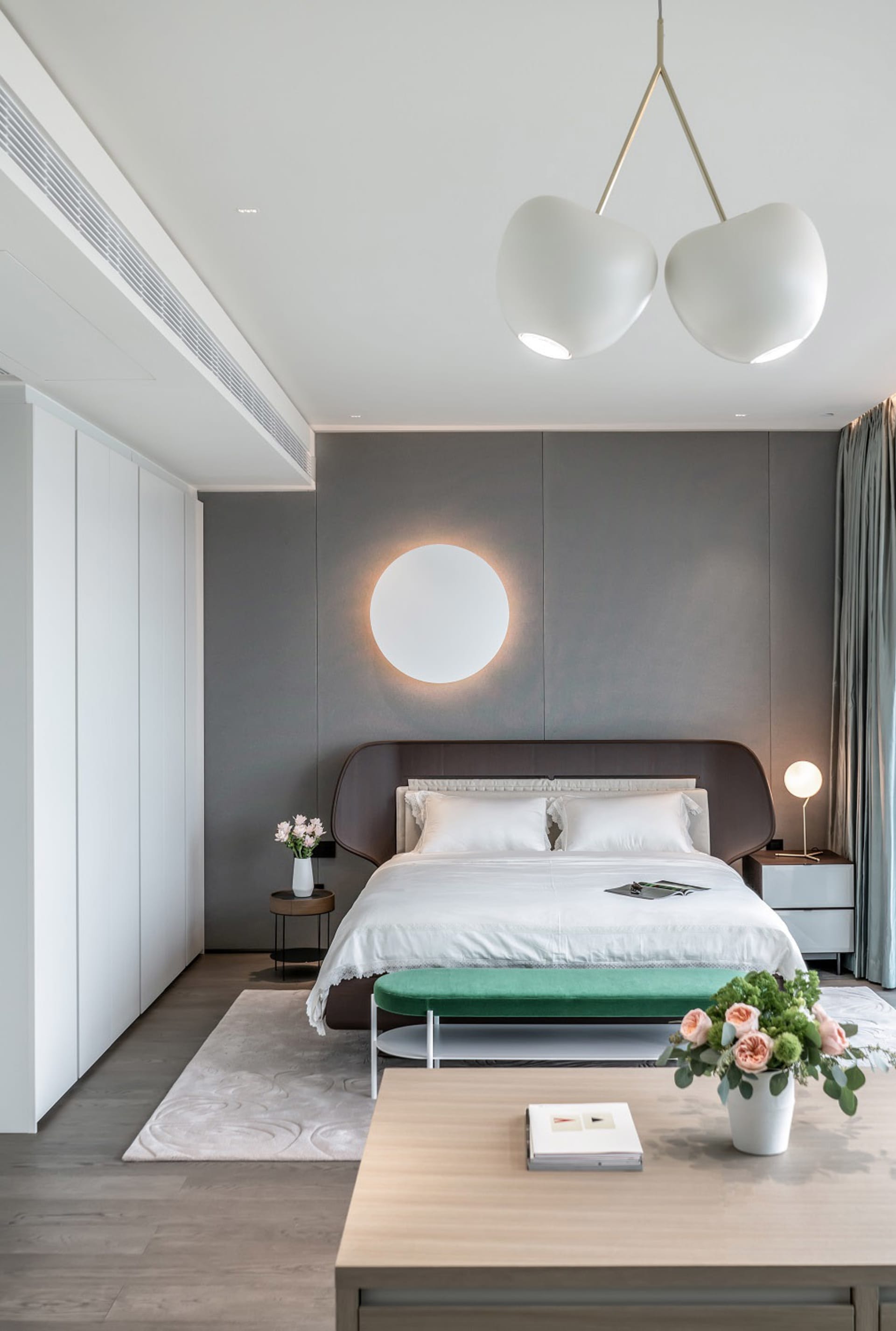 A serene, minimalist bedroom with a sleek, low-profile bed, textured upholstery, and a minimalist design
