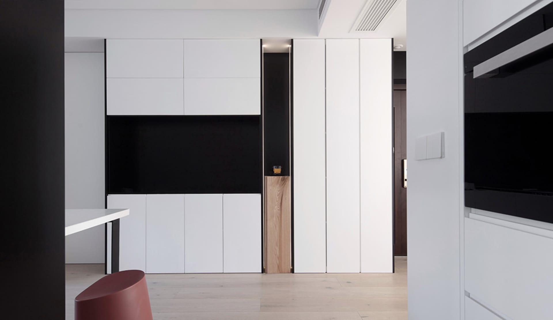 Modern interior design featuring minimalist white cabinets with black accents in a contemporary apartment setting.