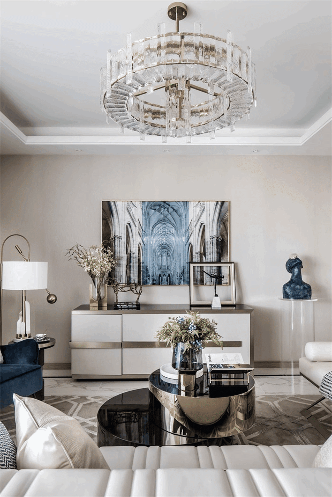 Modern living room with metallic furniture, glass accents, and fabric upholstery