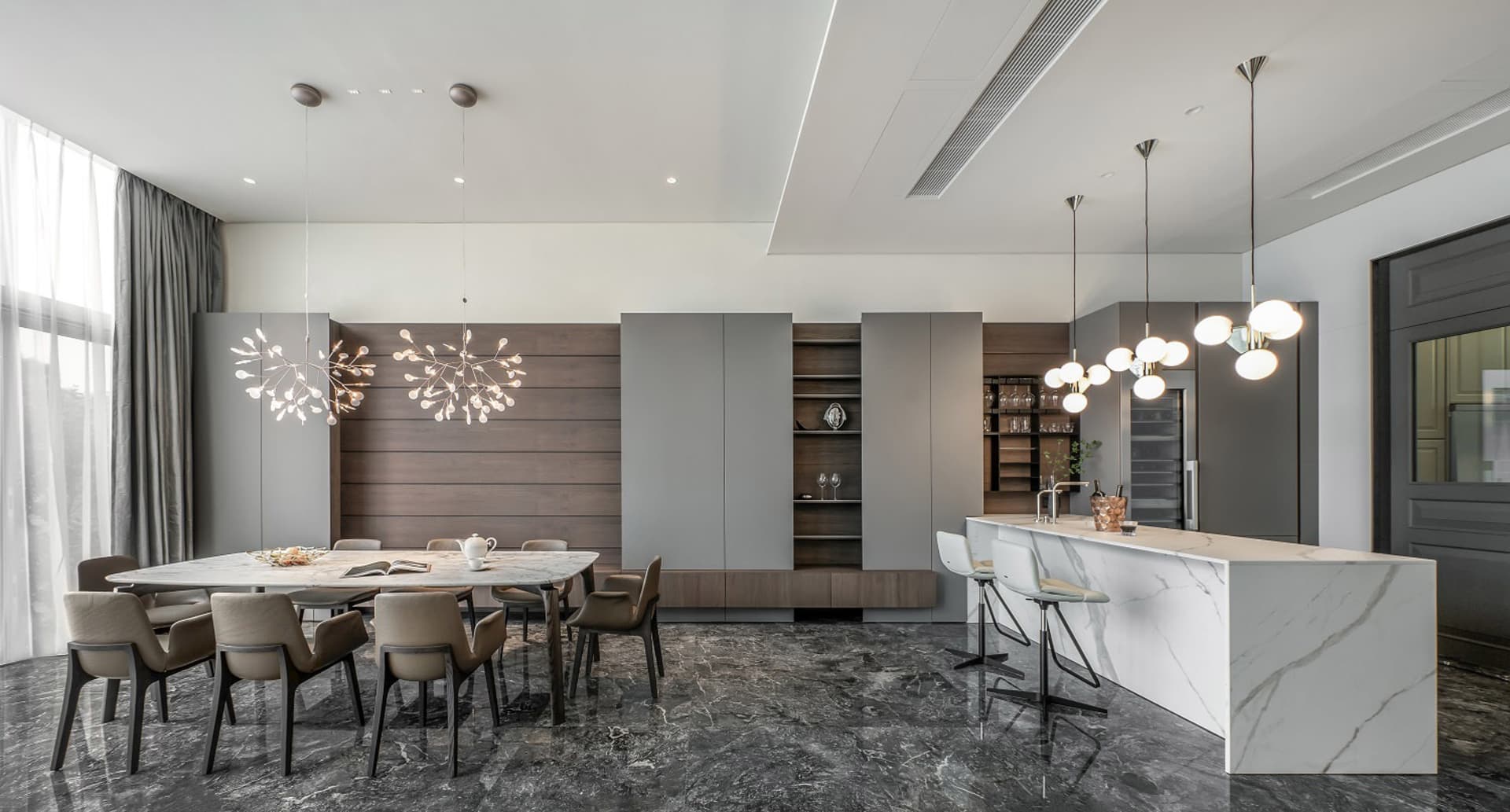 Modern minimalist living room with marble accents, featuring a sleek dining table and contemporary lighting fixtures.