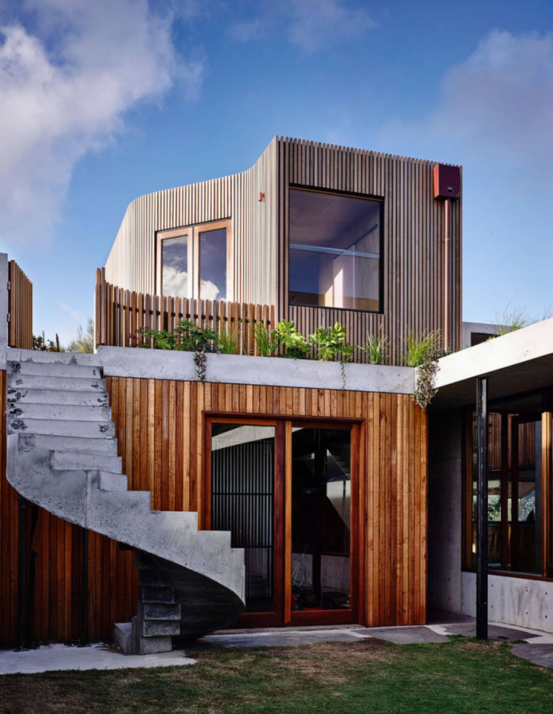 Modern residential exterior featuring wood and concrete materials.