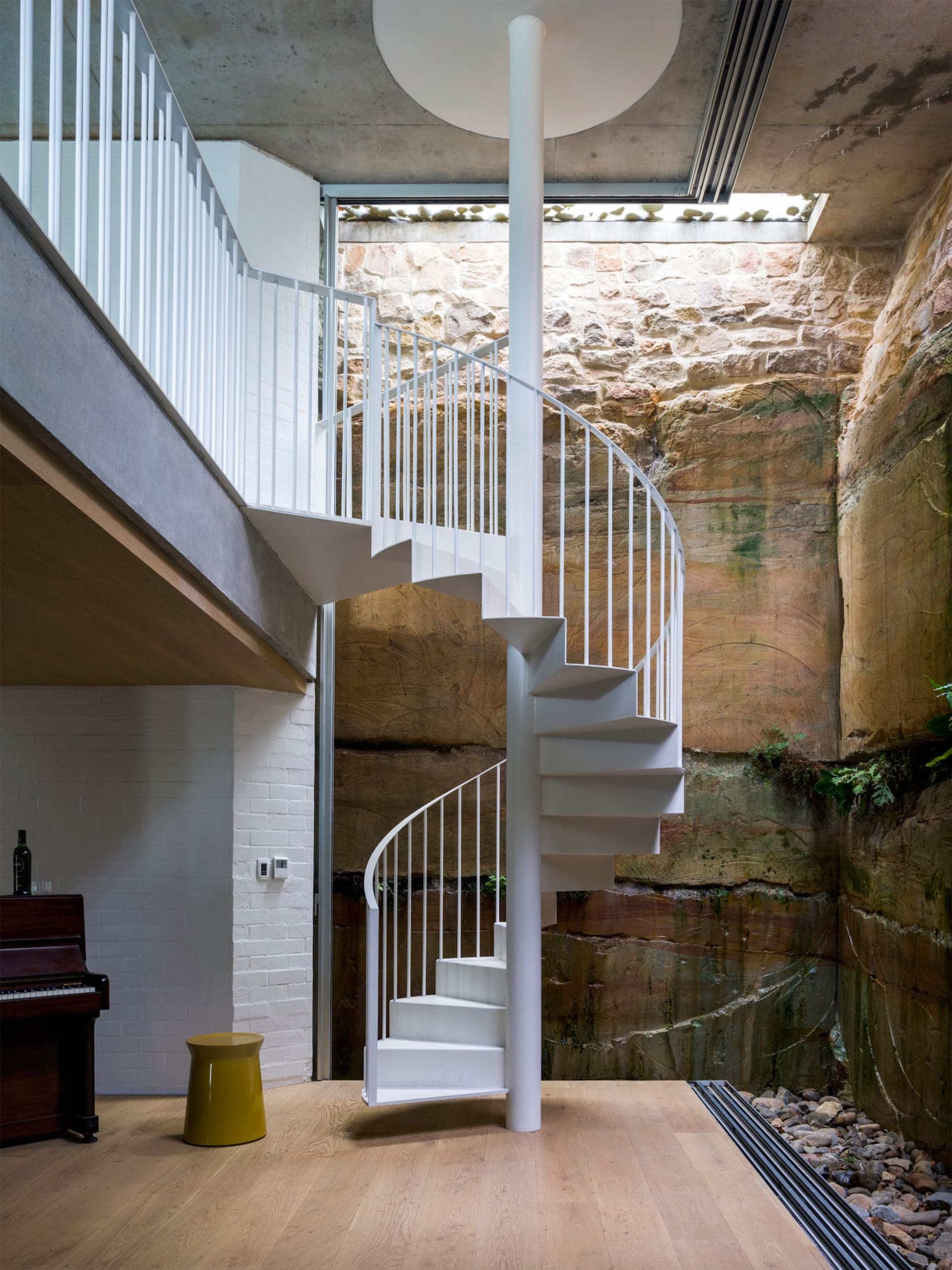 A minimalist white metal spiral staircase