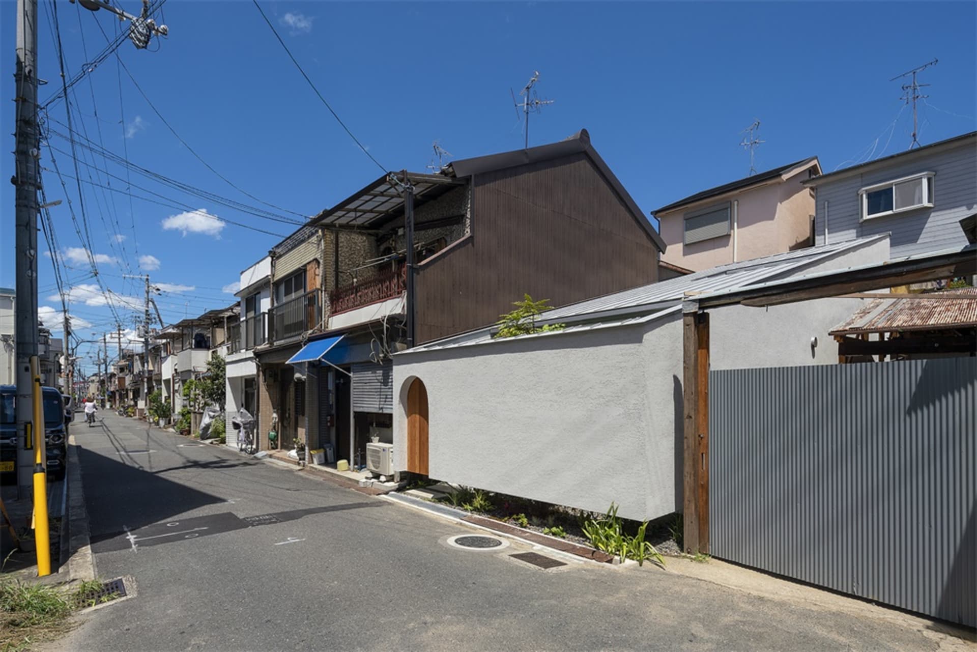A view of a modern urban residential street with concrete and glass buildings.