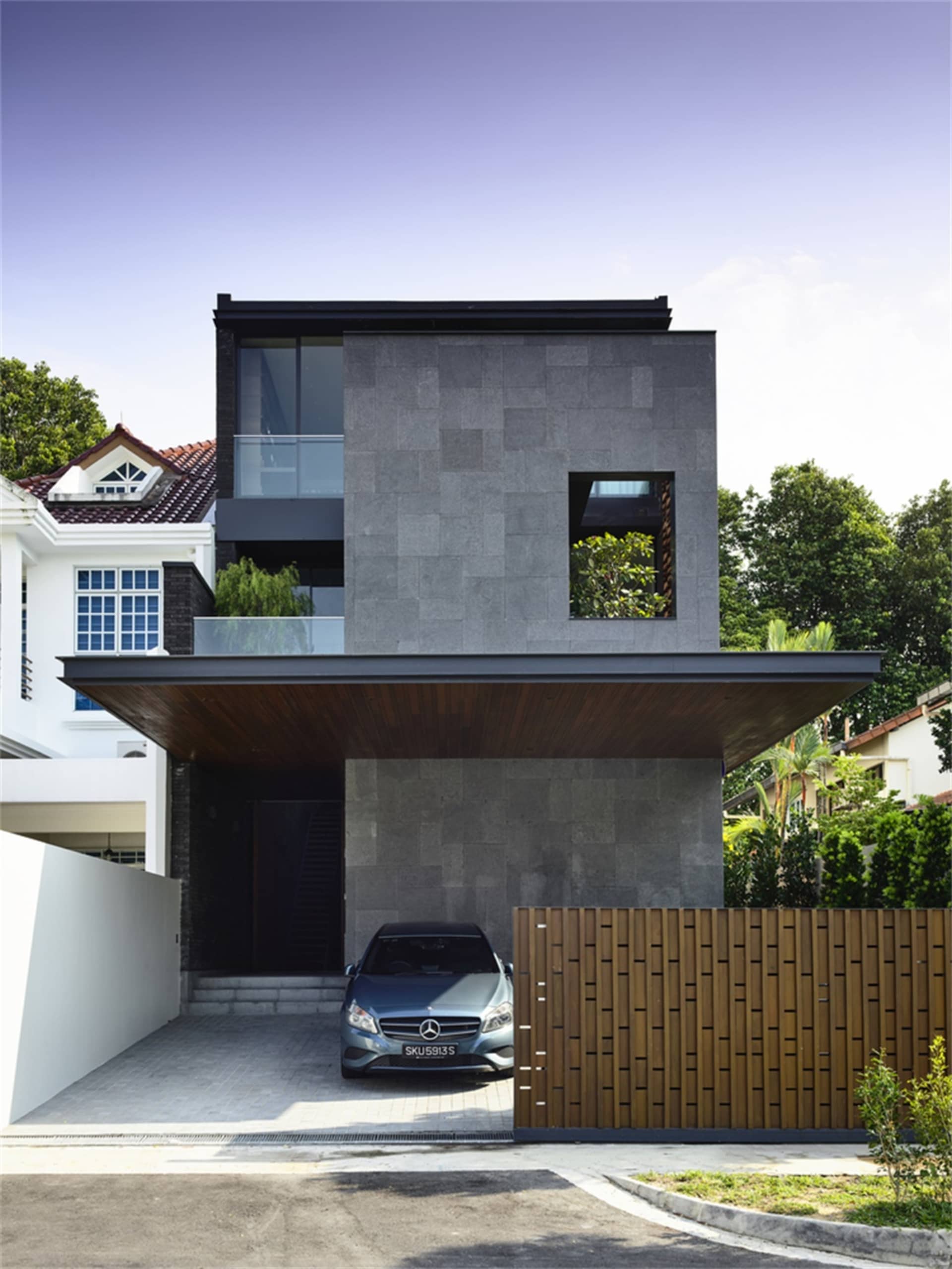 Modern architectural design featuring a contemporary residential house with concrete exterior and large windows.