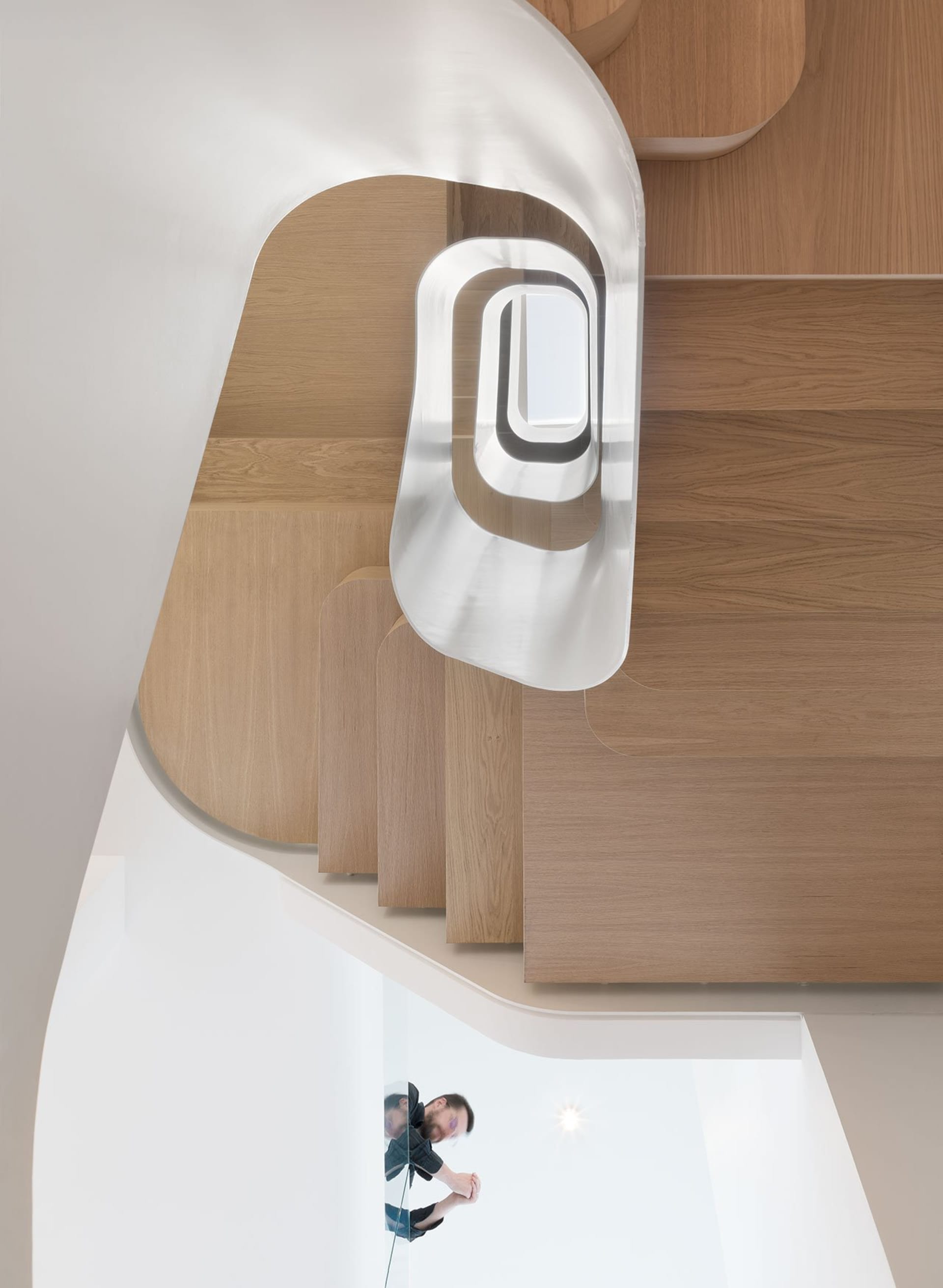 A modern interior staircase featuring aluminum railings and wooden steps.