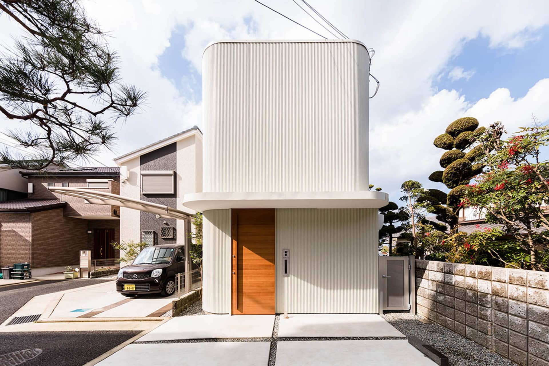 Modern residential house with white exterior and concrete columns.