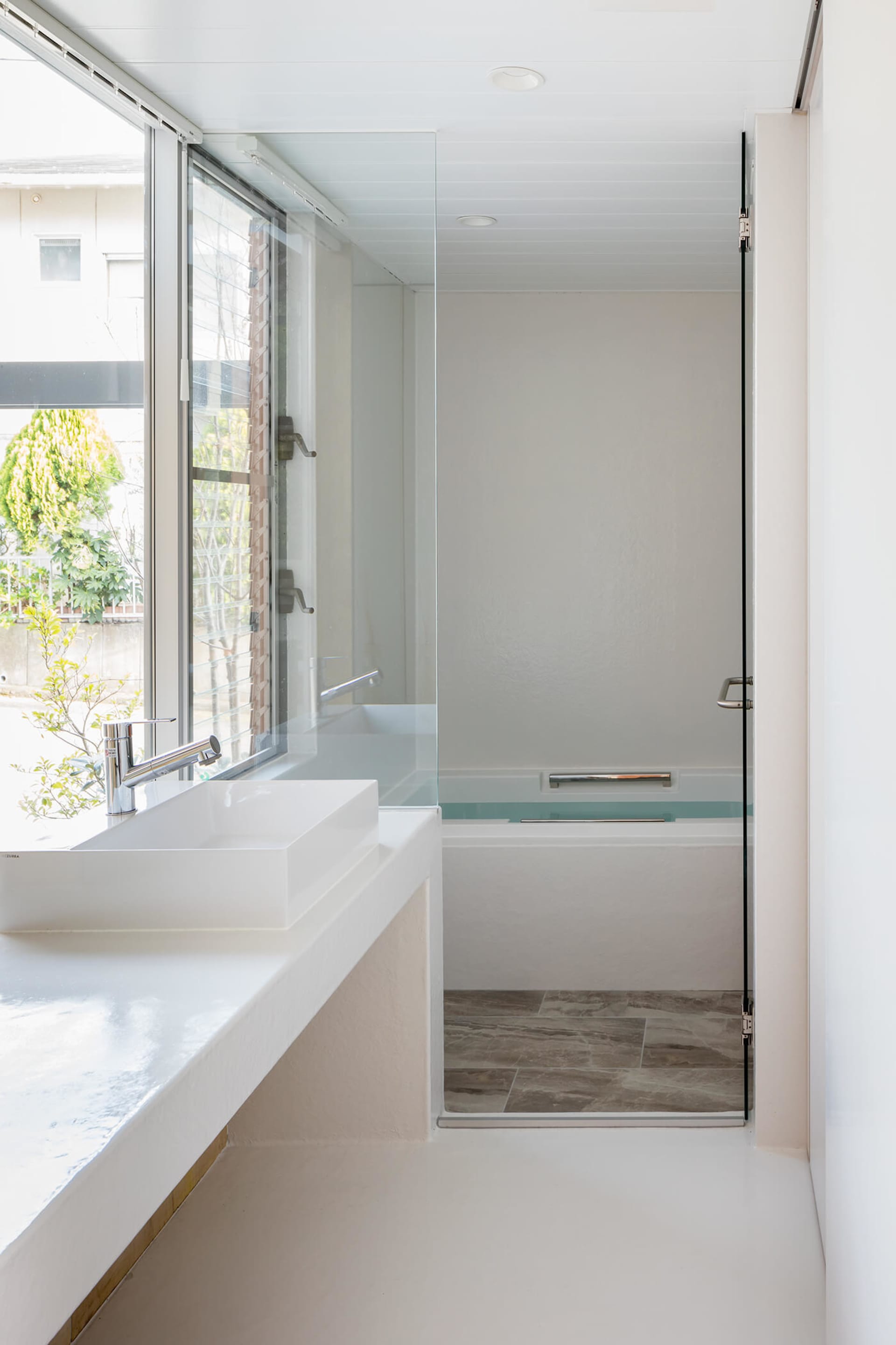 Minimalist bathroom featuring a glass shower enclosure and porcelain fixtures.