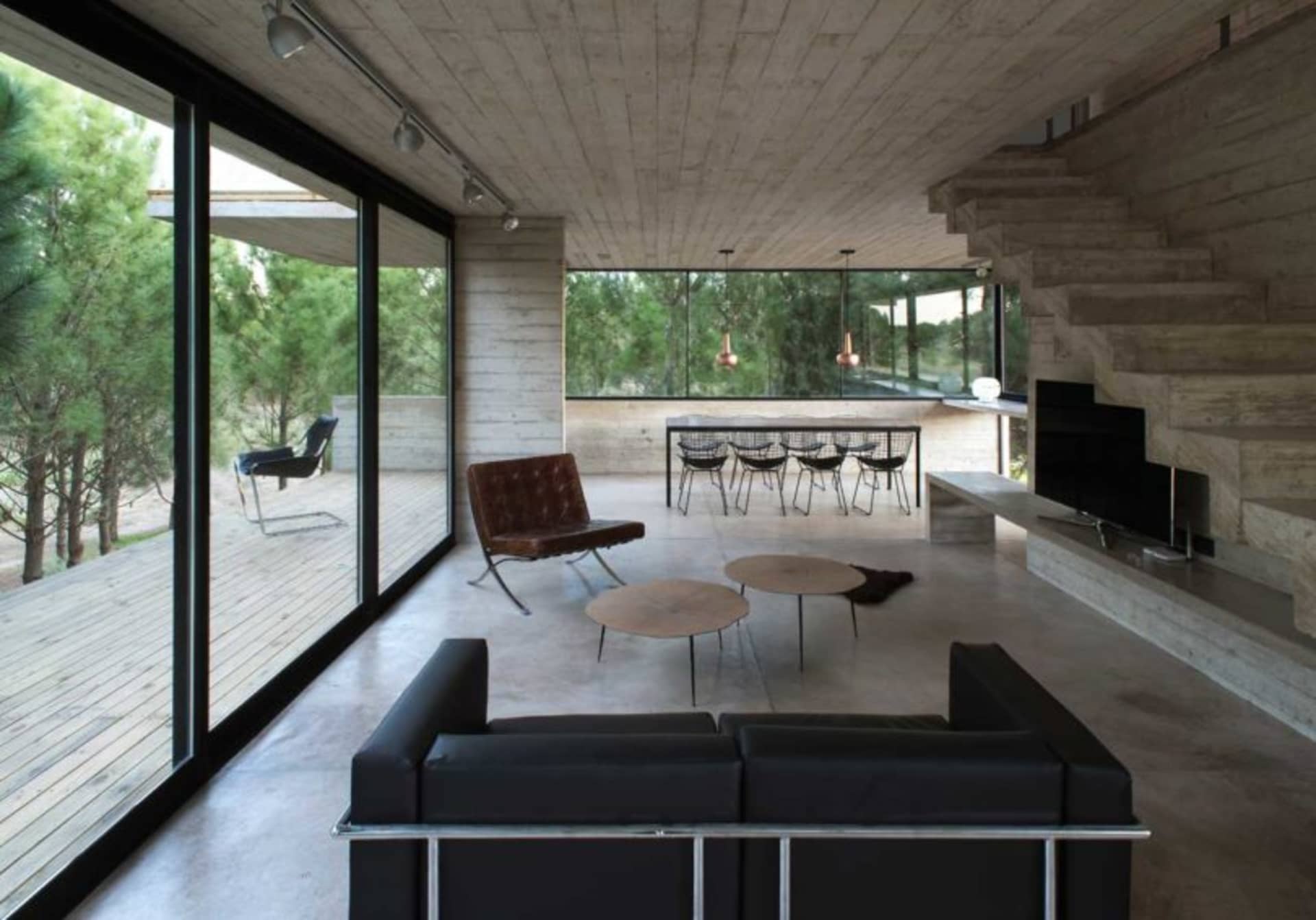 A modern living room with concrete flooring and minimalist furniture.