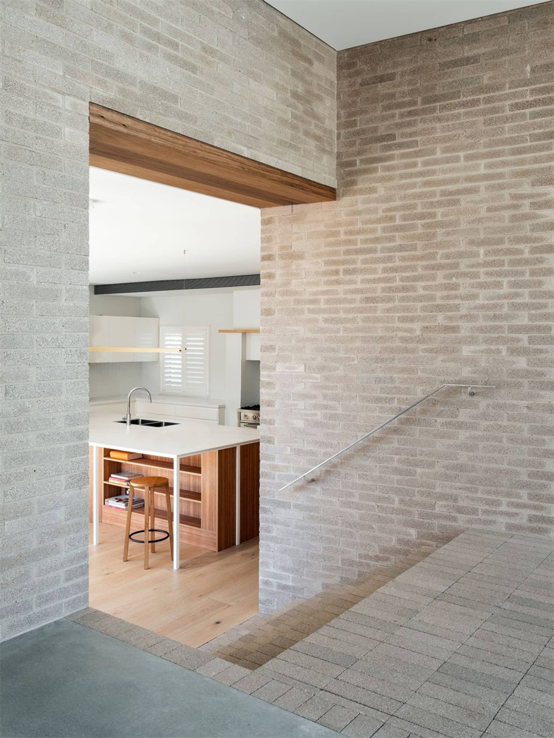 Modern kitchen with wood floor and white countertops.