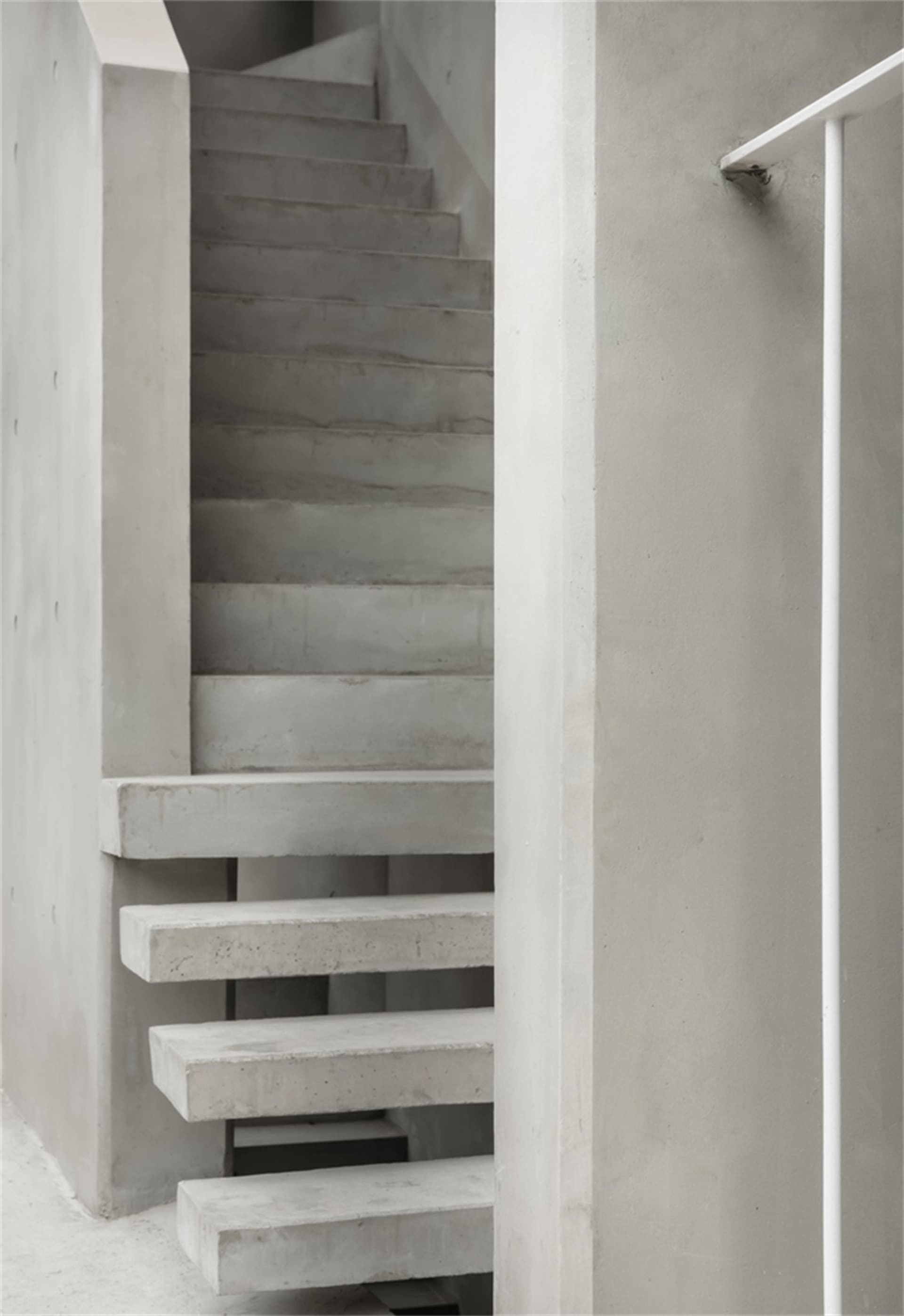Modern, minimalist concrete staircase with clean lines and industrial aesthetic.