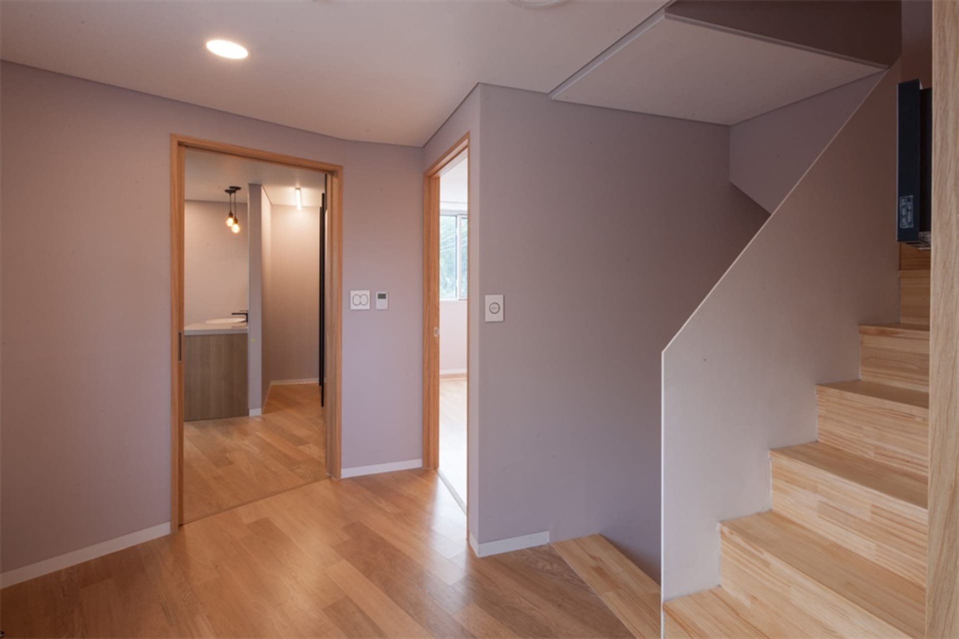 A modern home interior featuring wooden flooring and stairs.