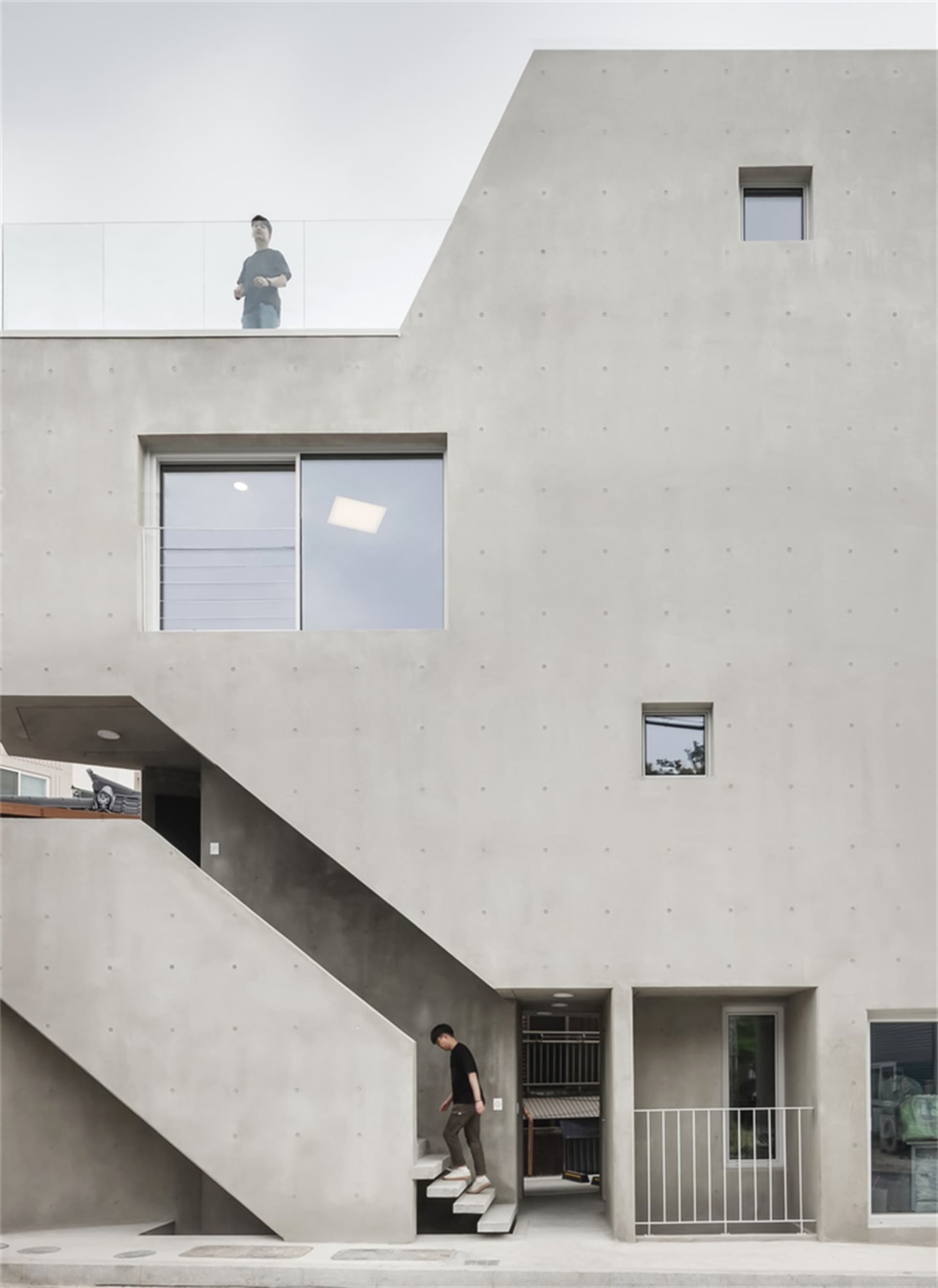 混凝土住宅建築採用現代建築設計,擁有簡約外觀與外部樓梯。
