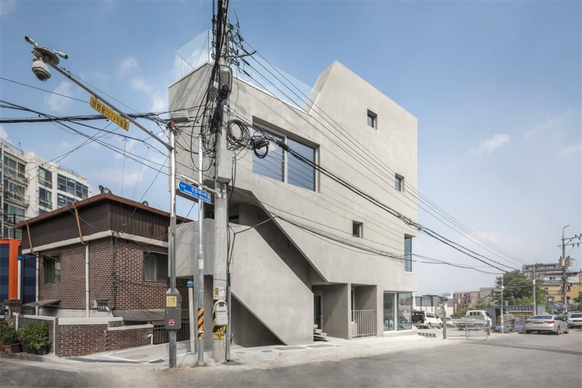 一棟擁有混凝土外牆與玻璃窗的現代住宅建築。