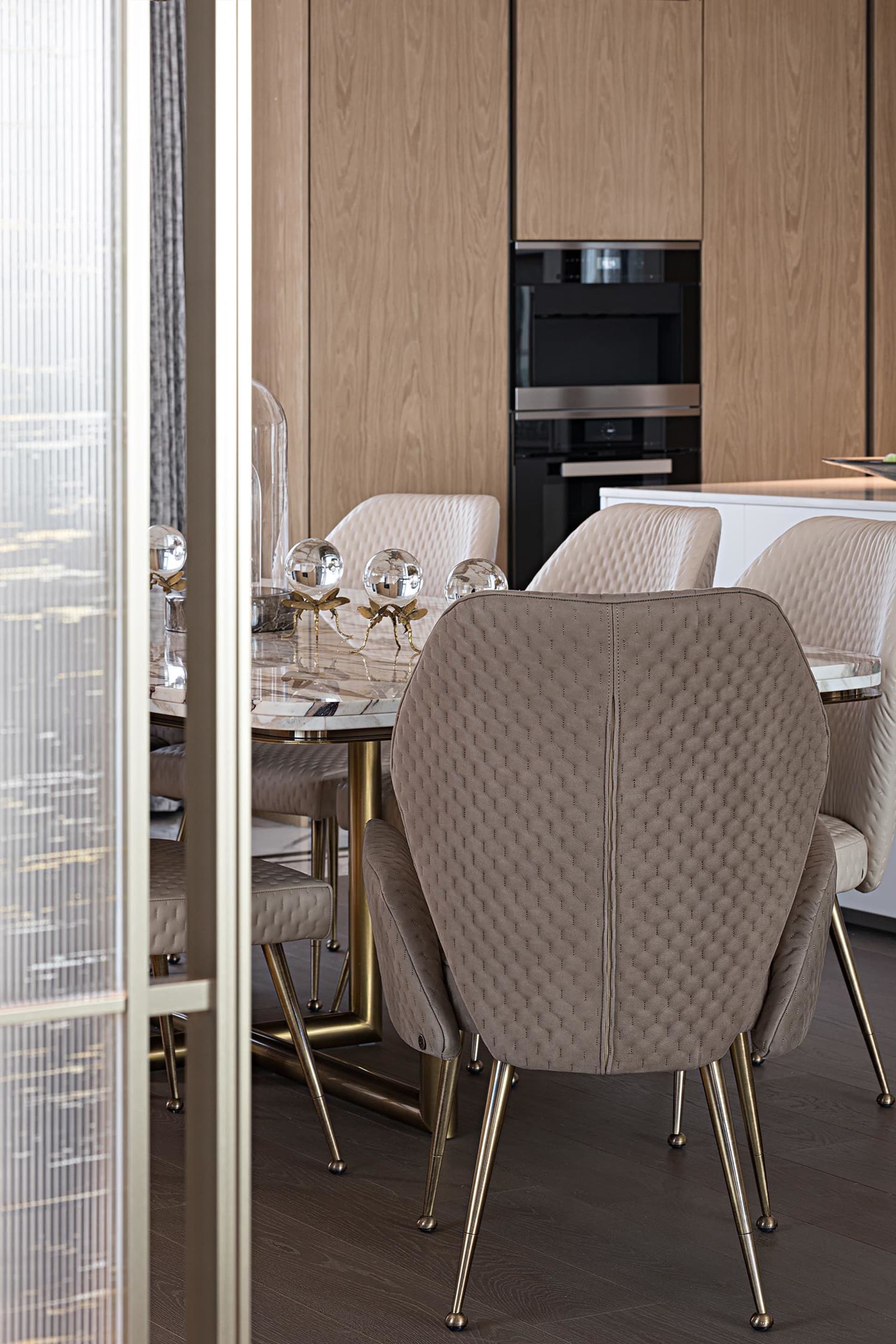 Modern marble dining room with elegant chairs and table centerpiece.