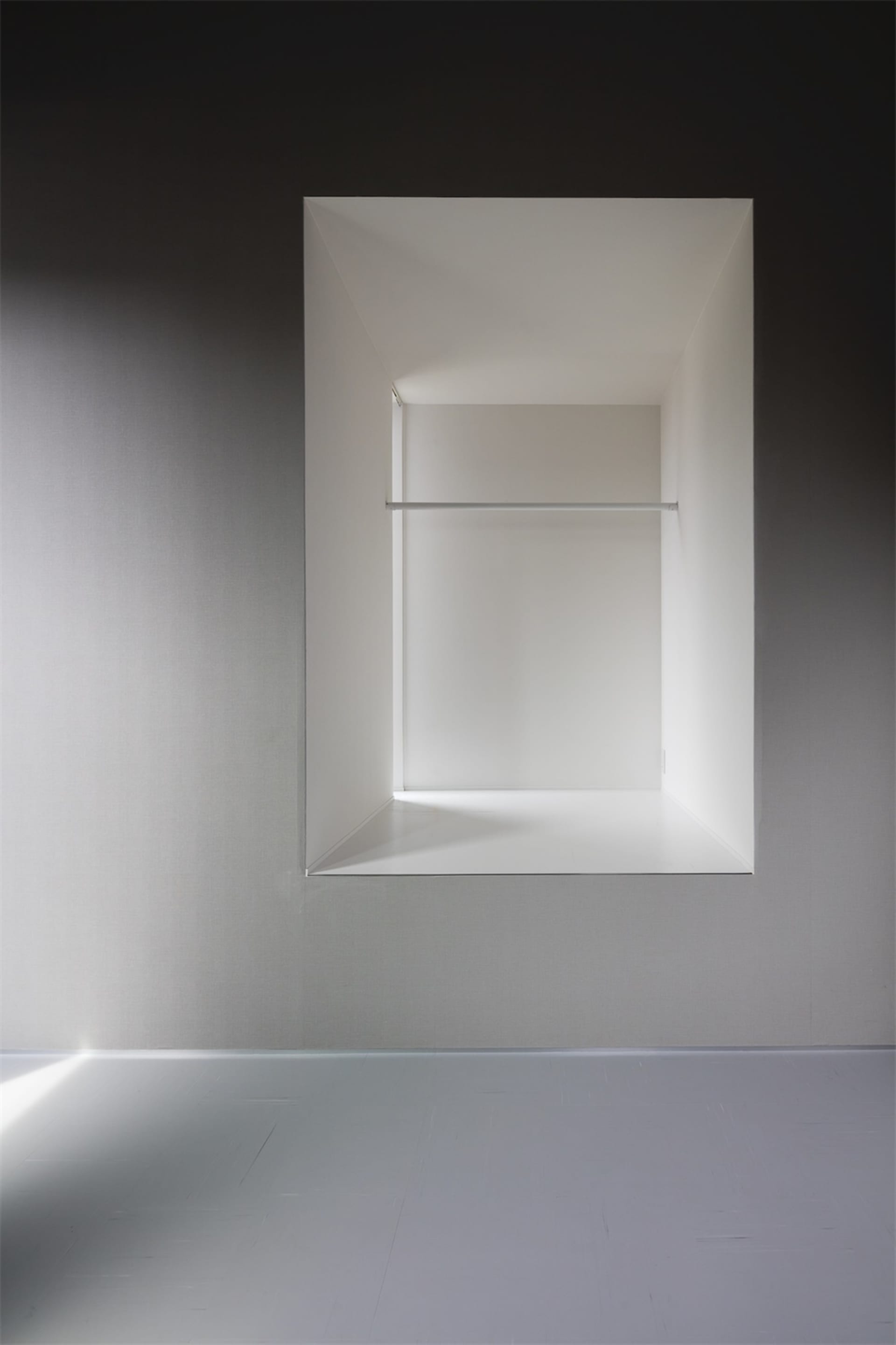 Modern bathroom with minimalist design, featuring concrete walls and floor.