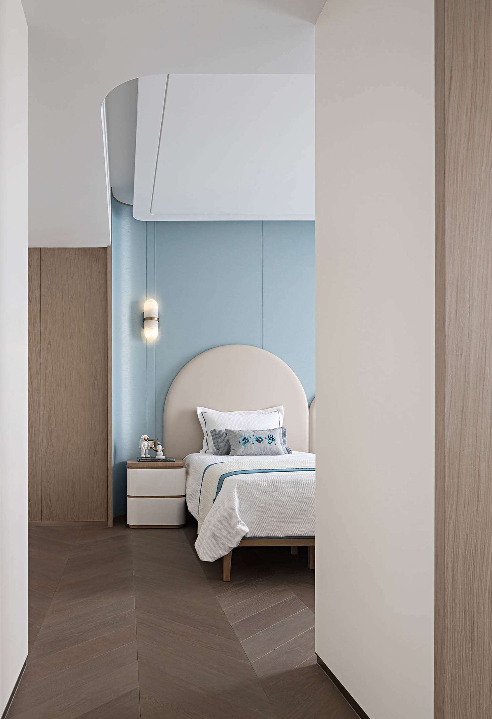 Modern bedroom with a wooden bed and blue accent wall