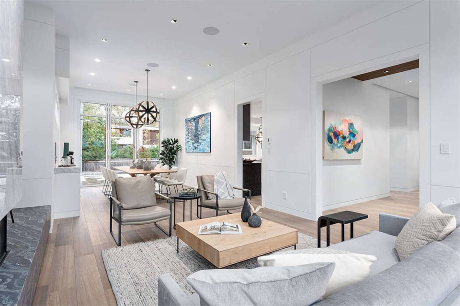 A modern living room featuring wood flooring, leather chairs, and a comfortable sofa.
