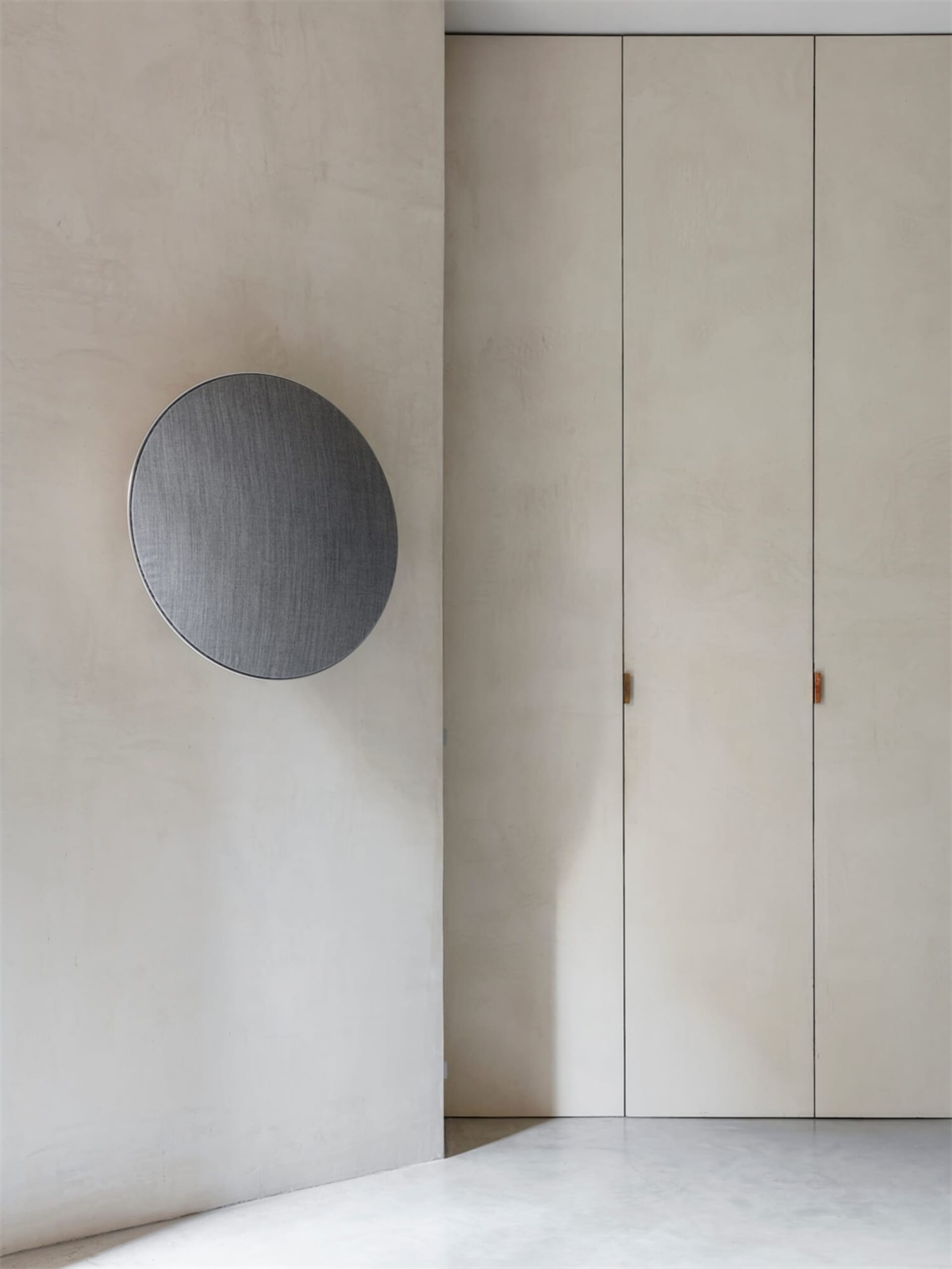 Sparse minimalist room featuring concrete finishes and simple design elements.