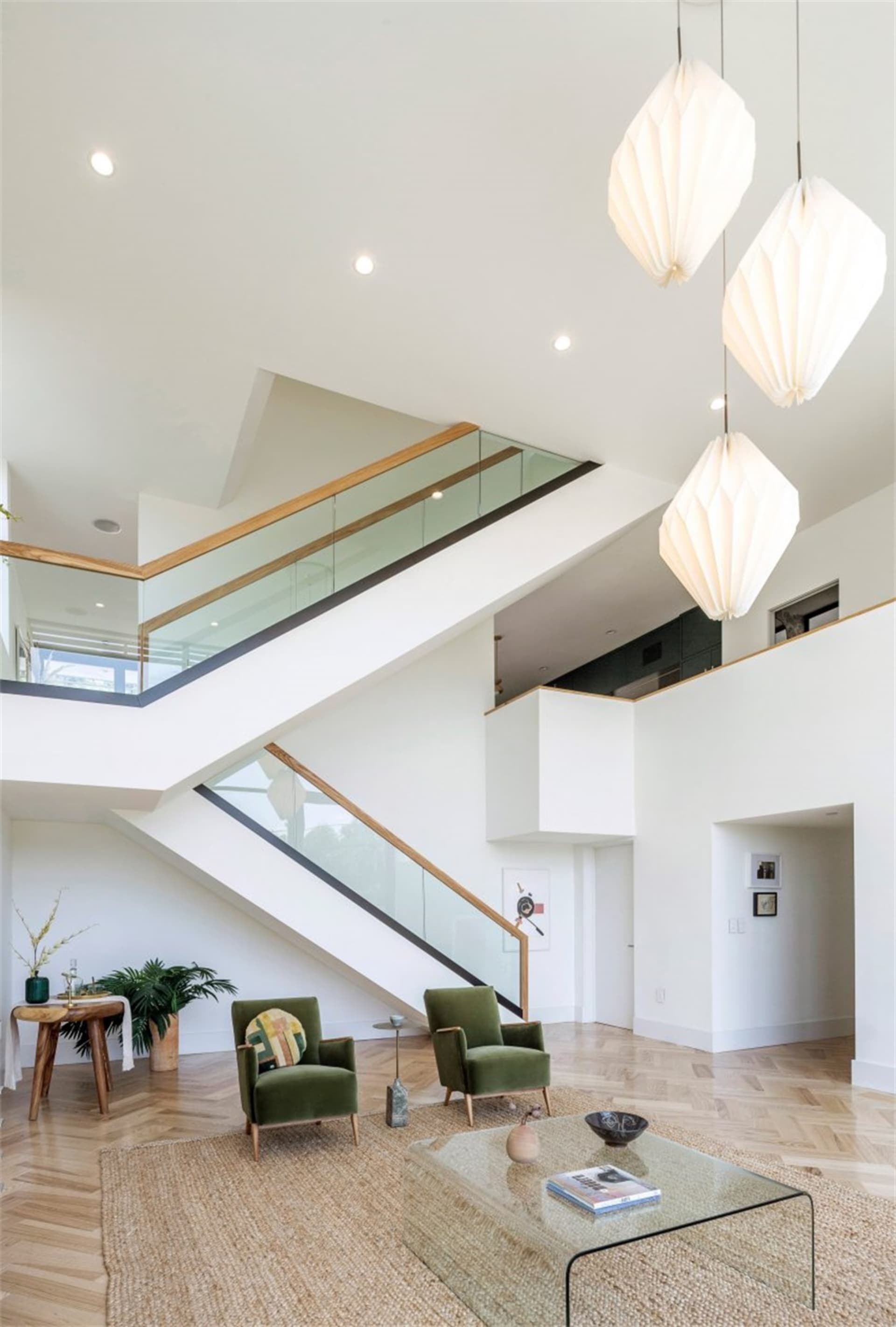 A modern living room features glass, metal, and wood materials.