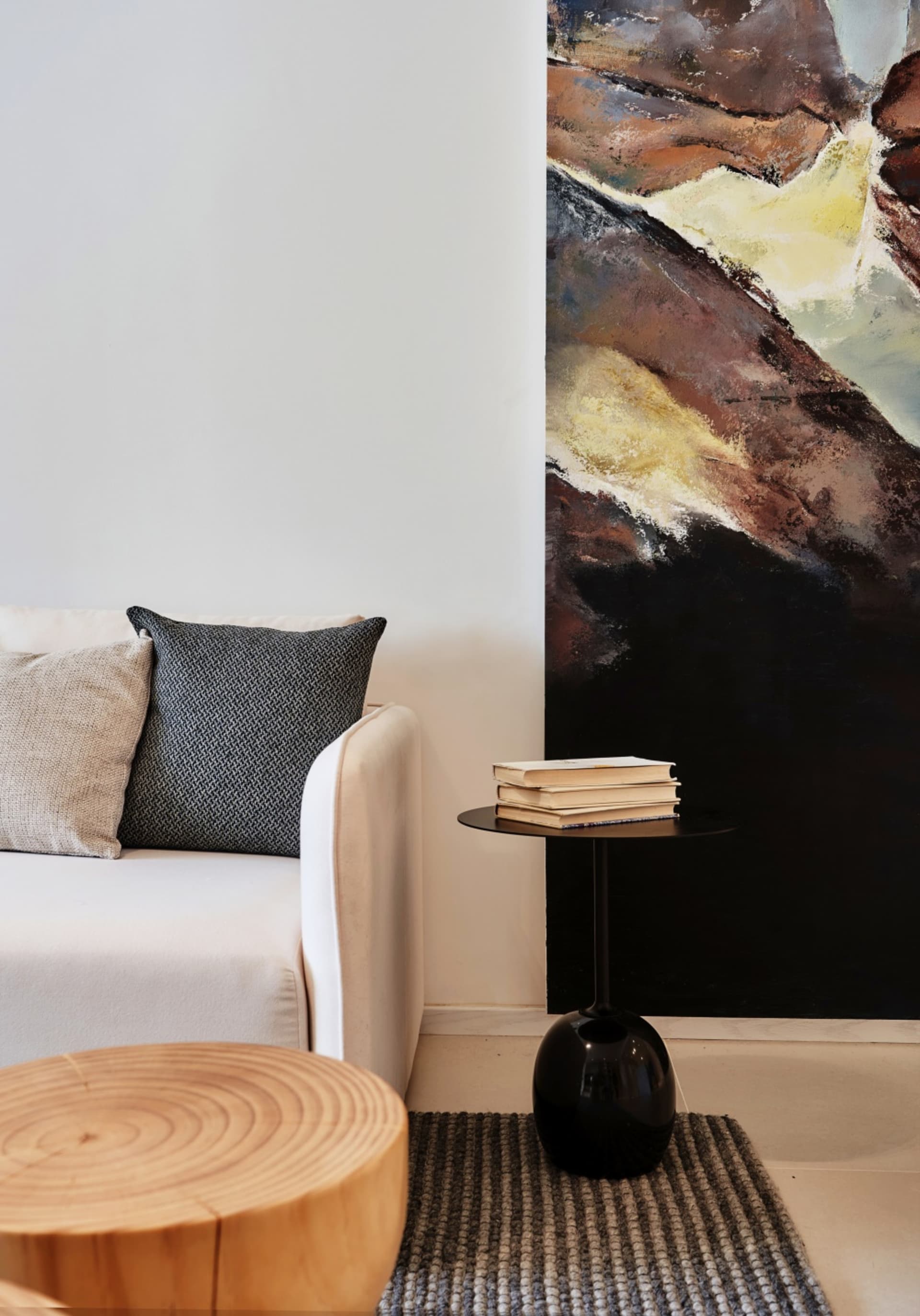 Modern interior design showcasing a black side table with a minimalist aesthetic, featuring a stack of books and a textured r