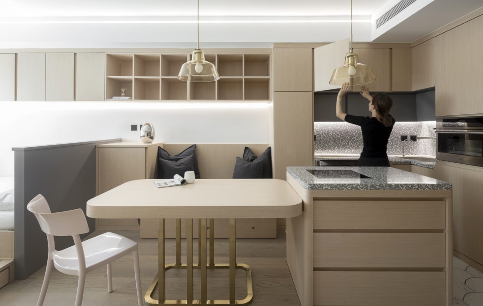 Modern minimalist kitchen featuring wooden cabinets, marble countertop, and metal accents.
