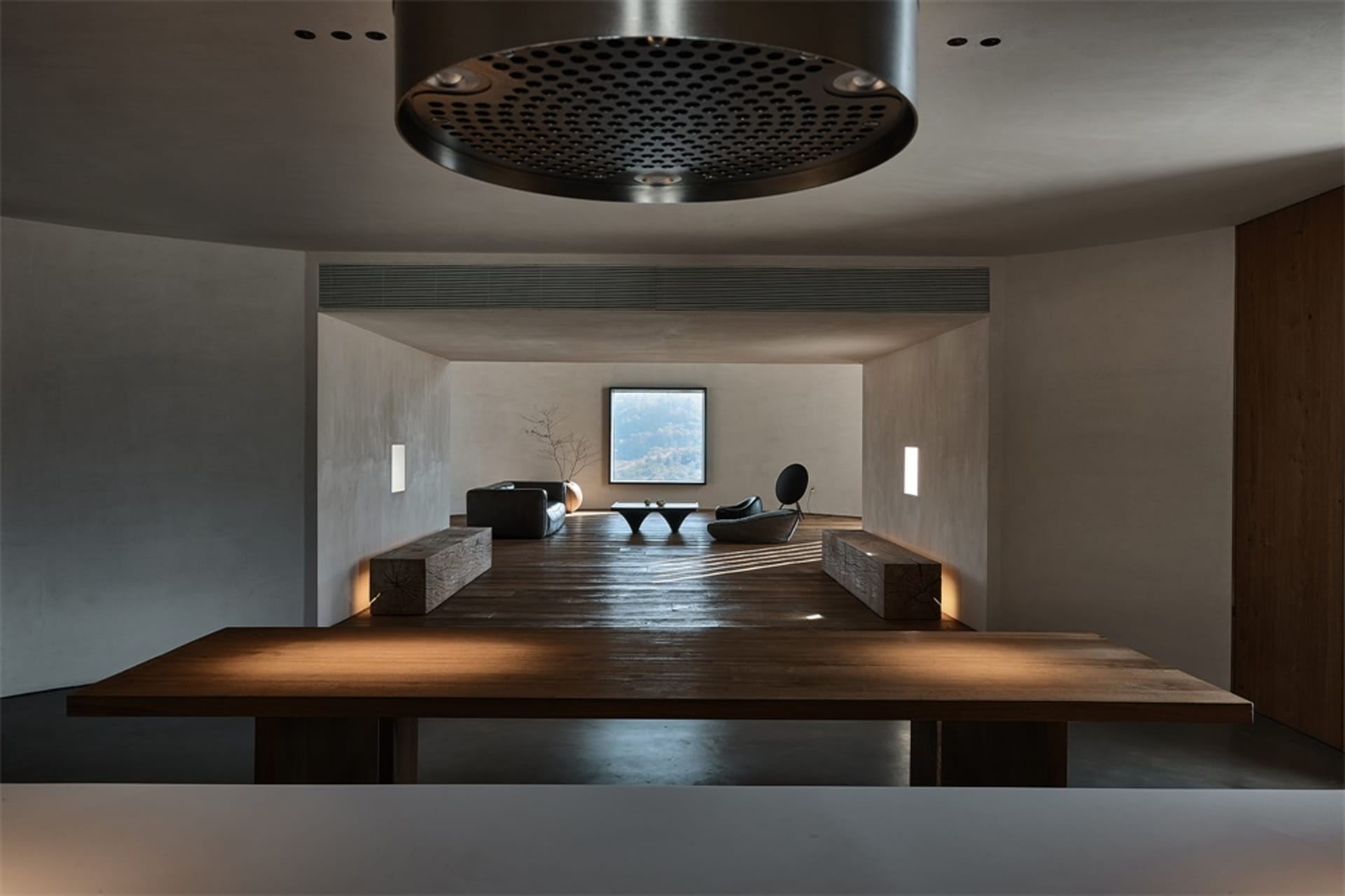 Modern minimalist lounge area with wooden flooring and furniture.
