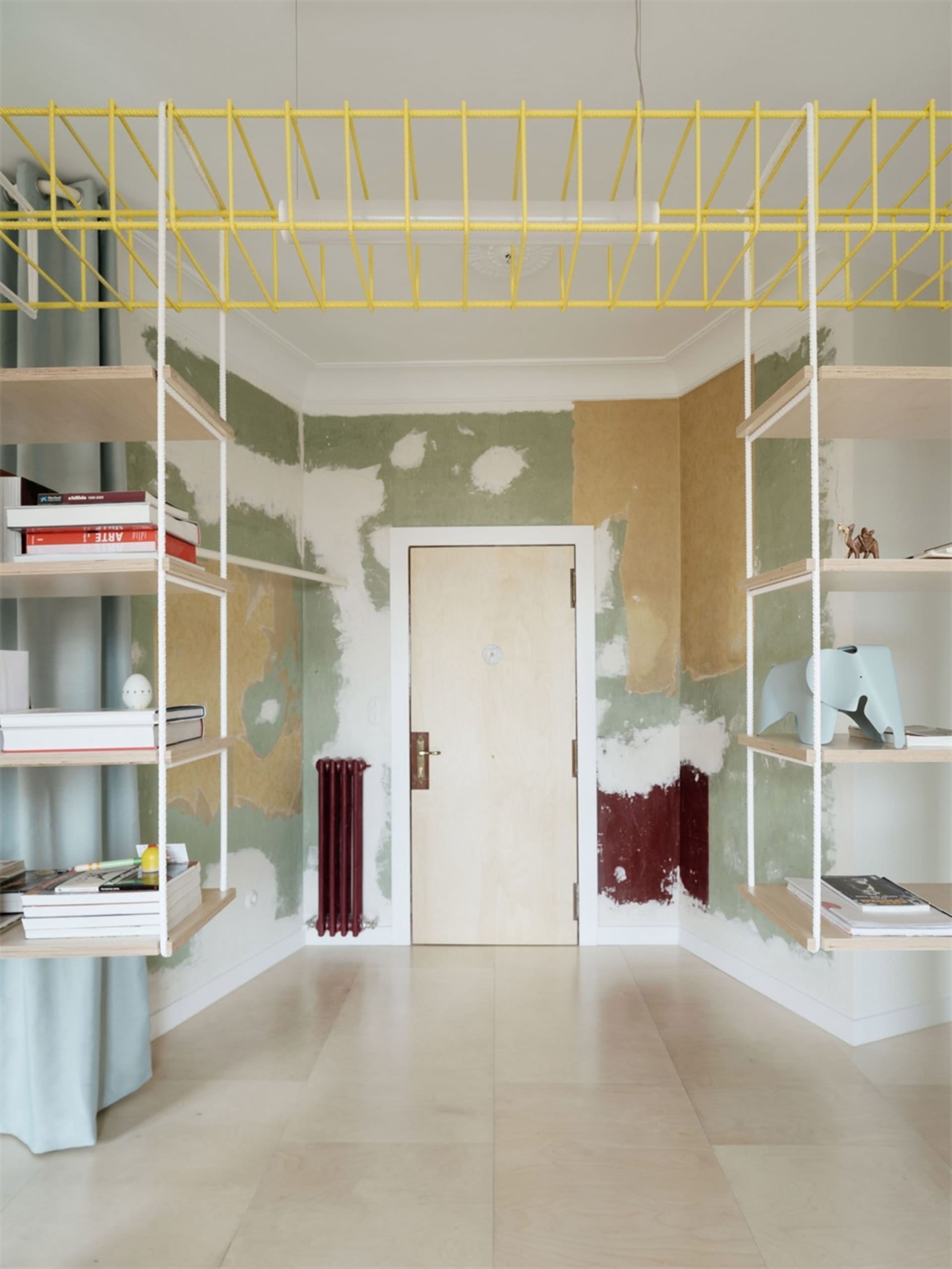 Minimalist room featuring wooden furniture, rope shelves, and metal accents.