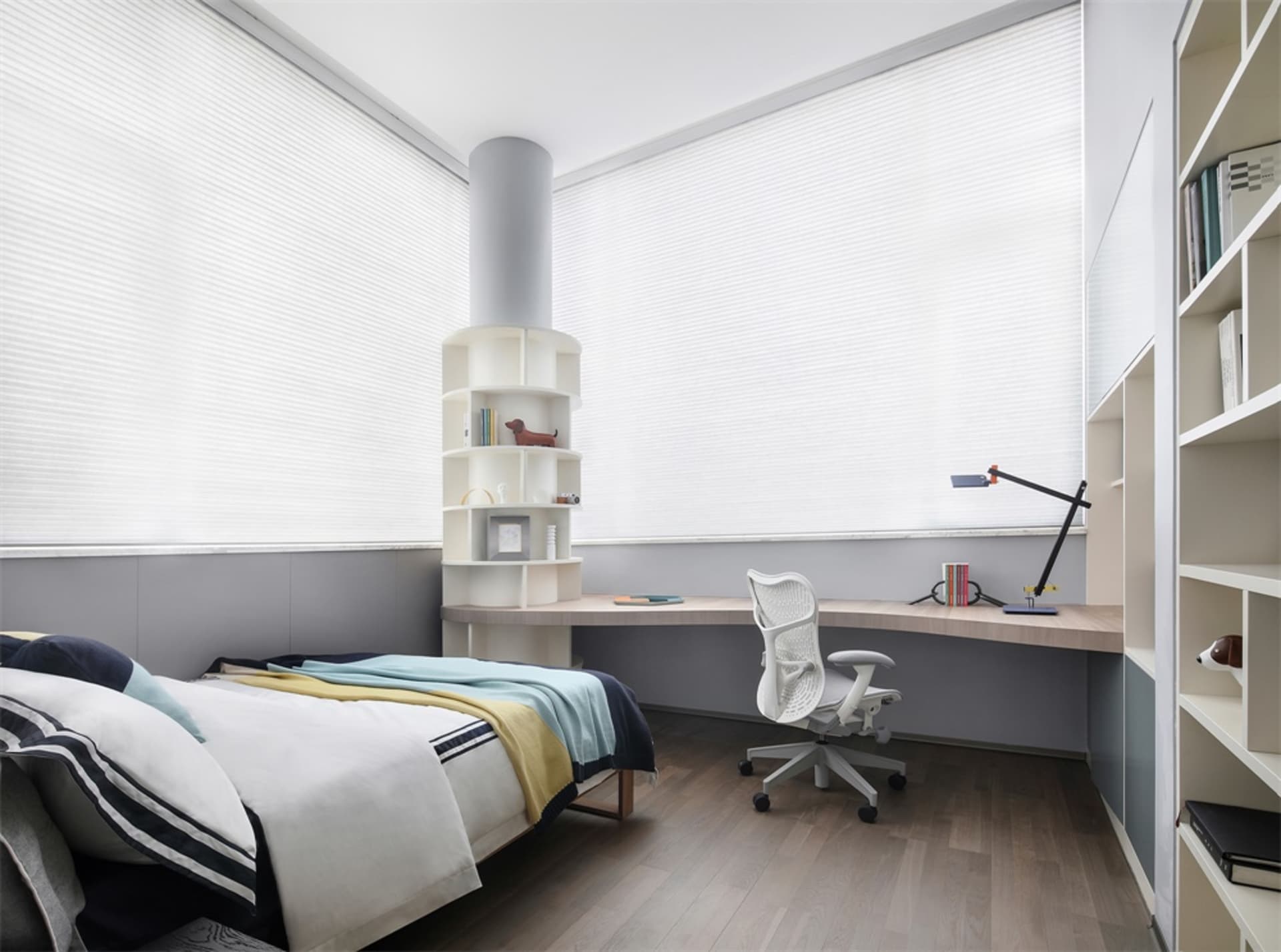 A modern bedroom with a wooden bed frame, a white desk, and built-in shelves.