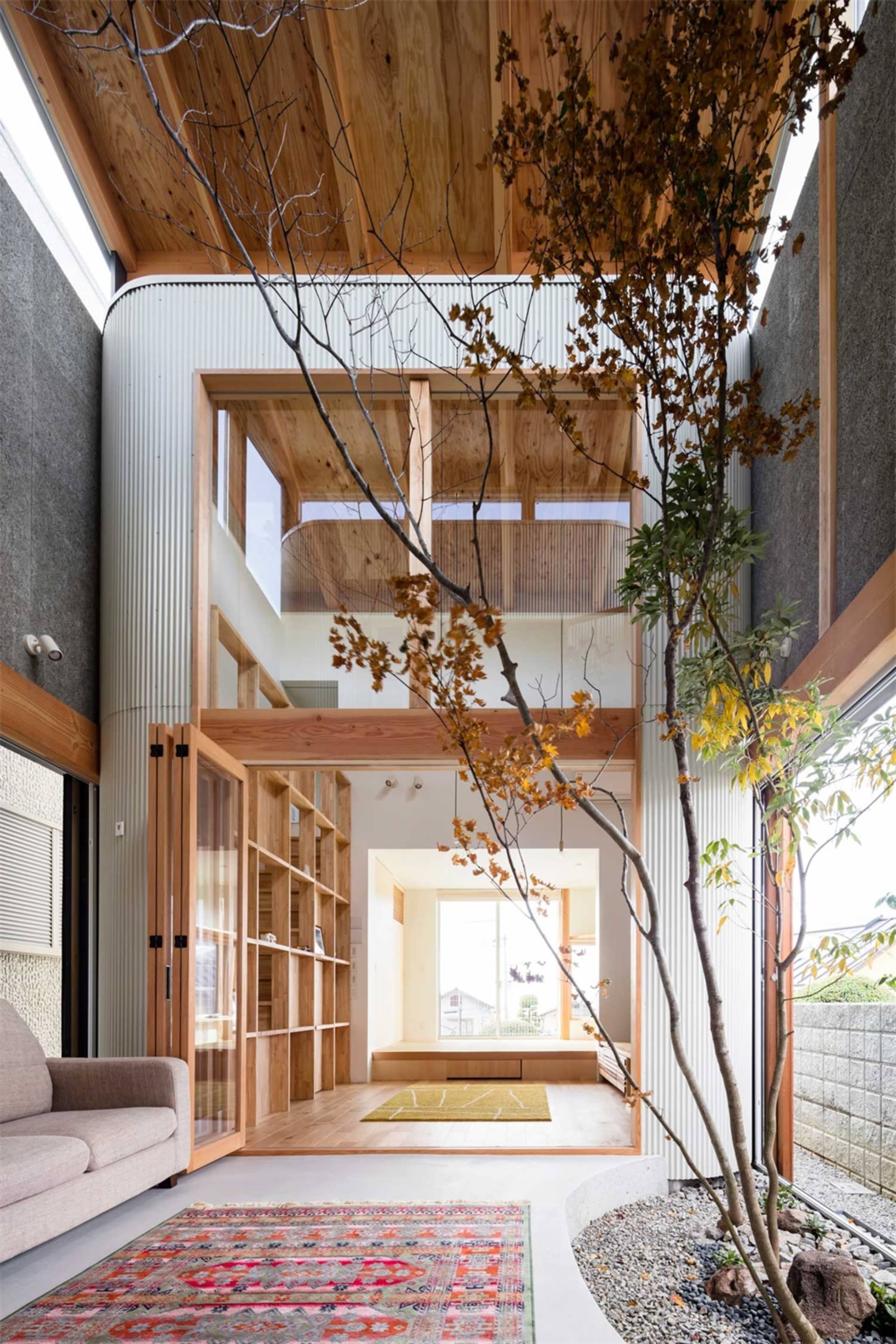 Interior of a modern living space featuring wooden beams, concrete flooring, and corrugated metal walls.