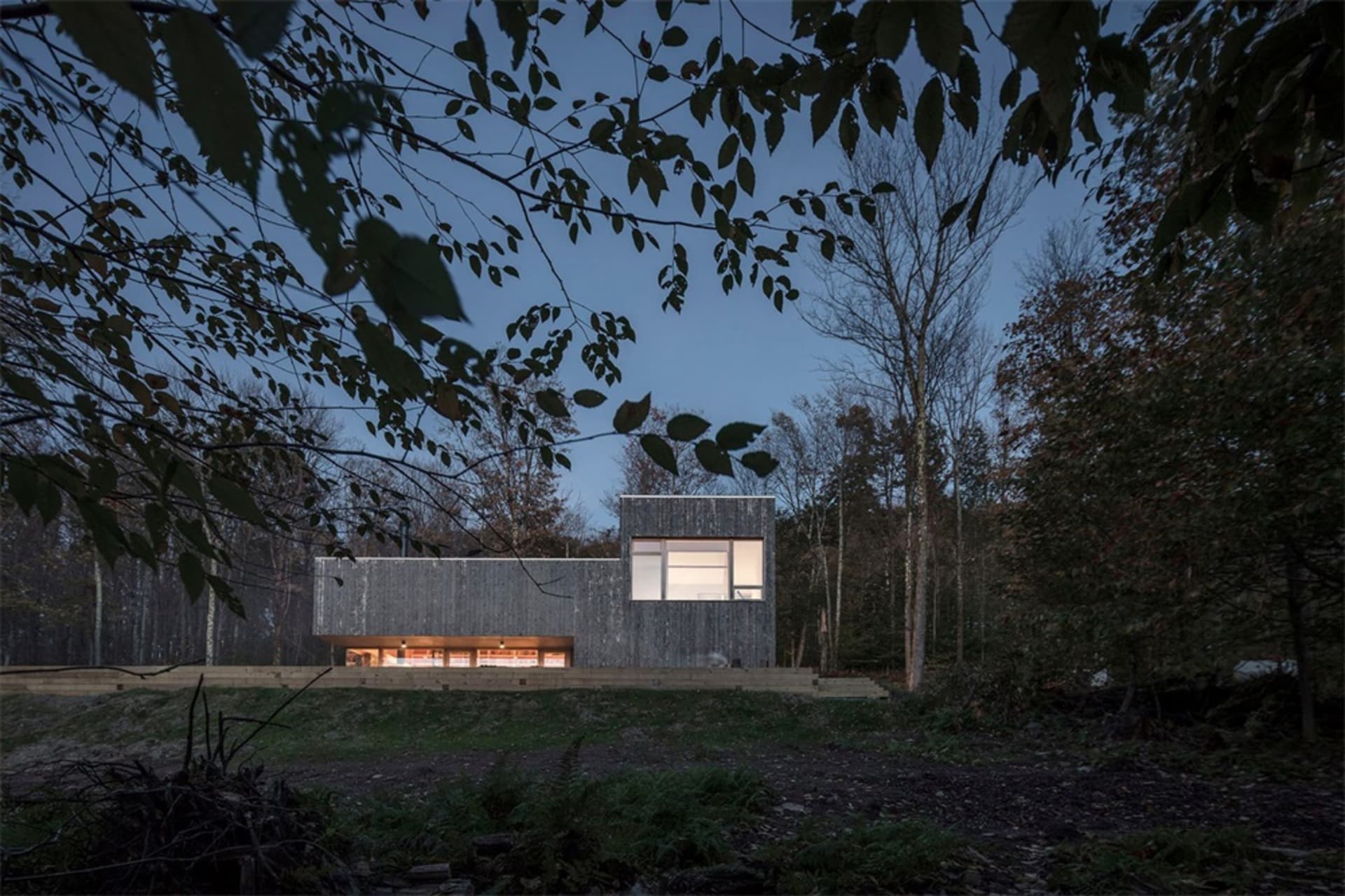 A modern house with wood exterior and large windows.