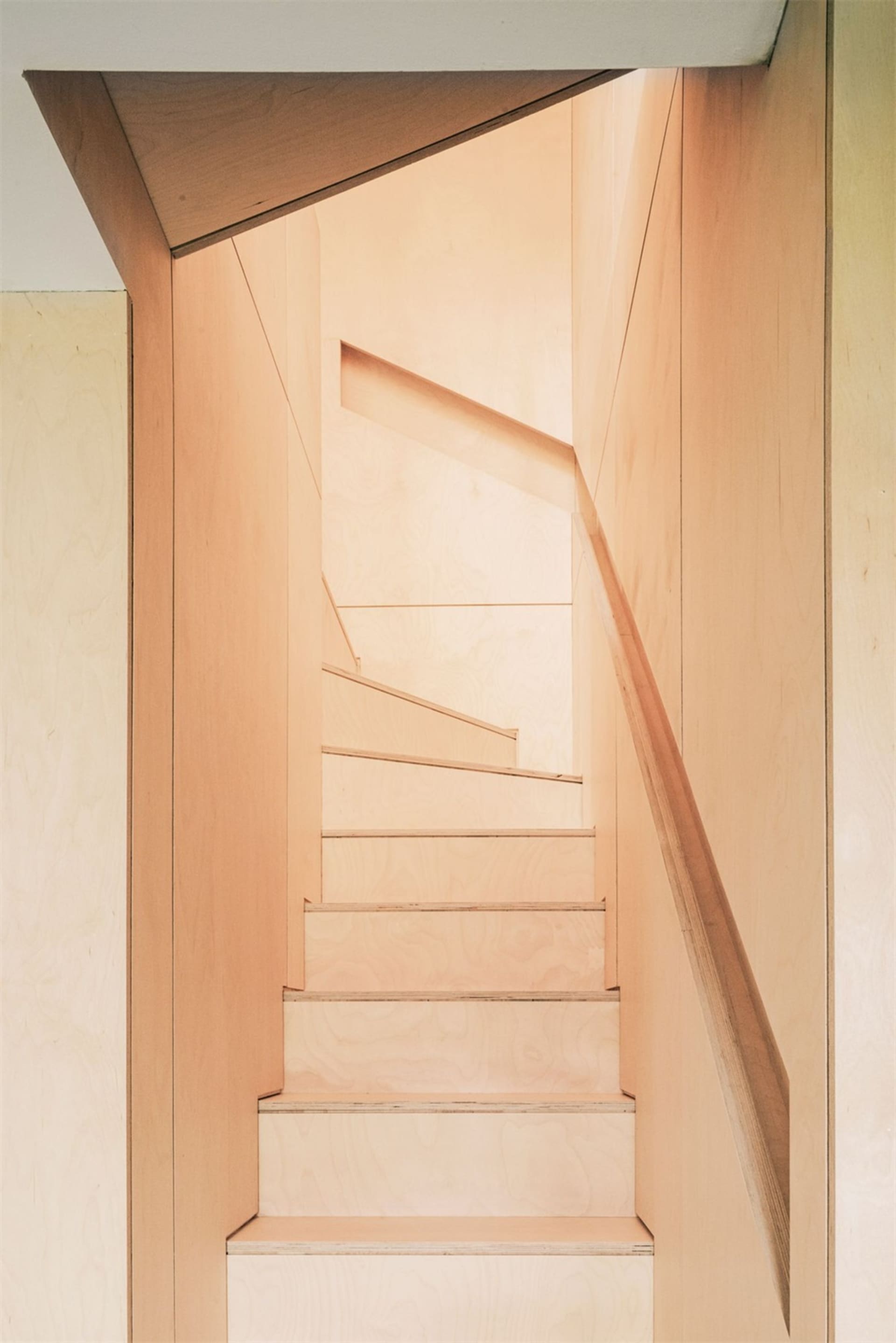 A modern wooden staircase interior with sleek, minimalist design.