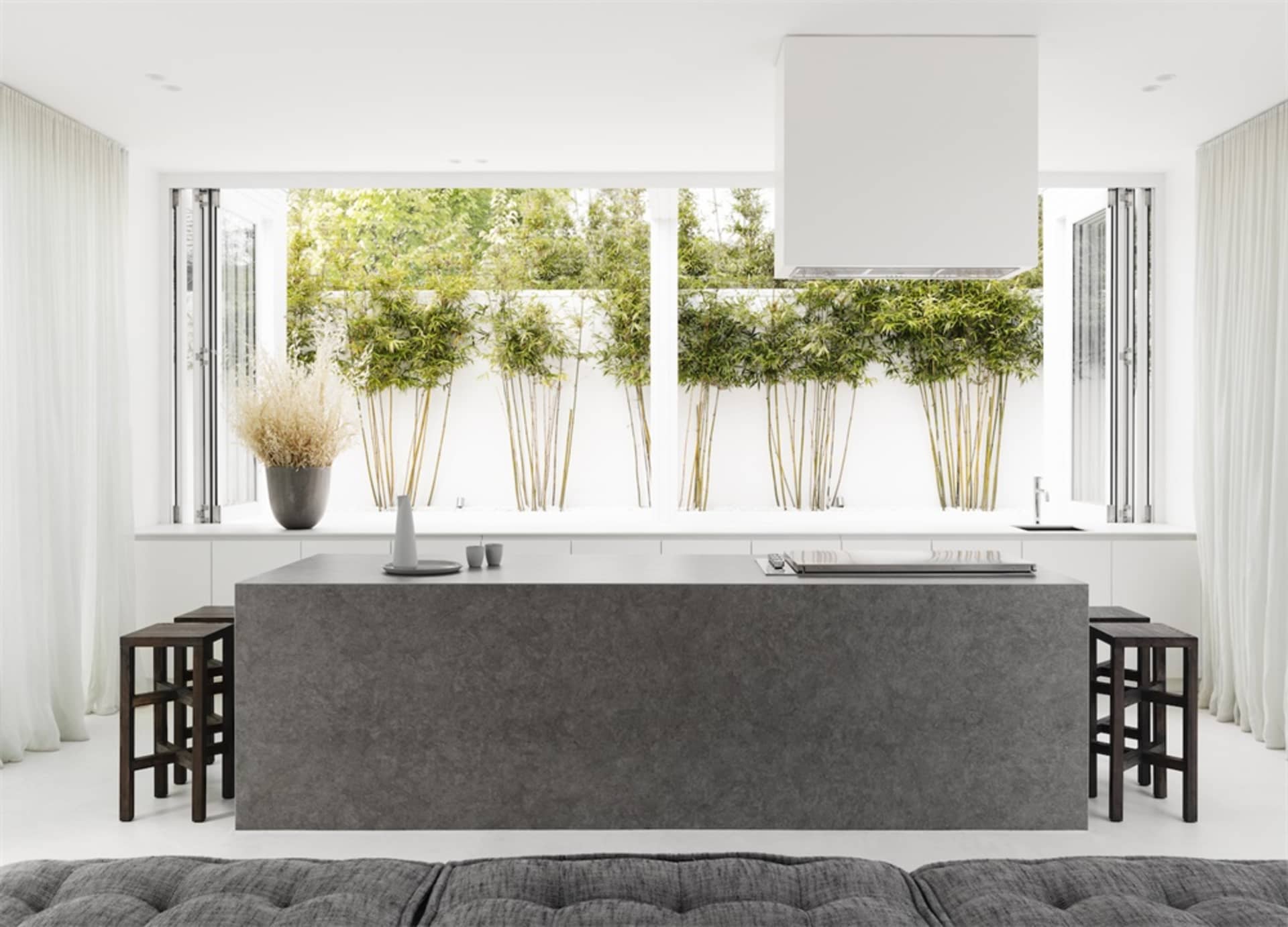 Photograph of a modern kitchen featuring a concrete island with minimalist design.