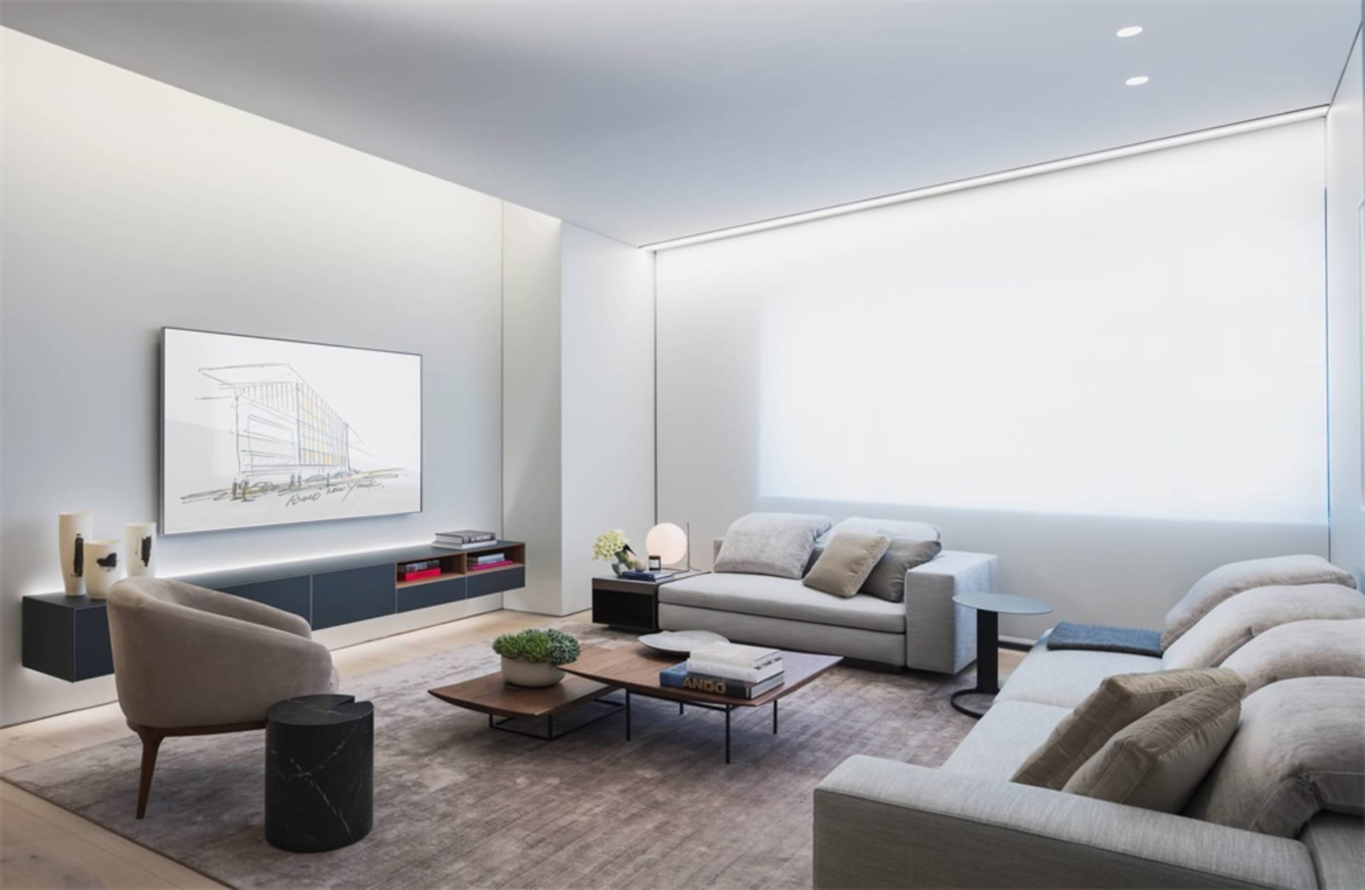 Contemporary modern minimalist living room setting featuring light-colored furniture, grey sofa, and light brown armchair wit