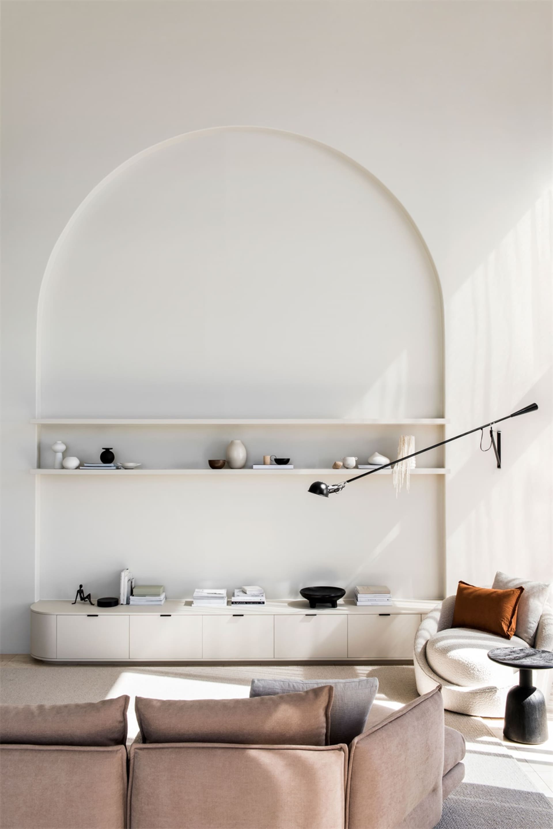 A minimalist living room with neutral-toned furniture and walls.