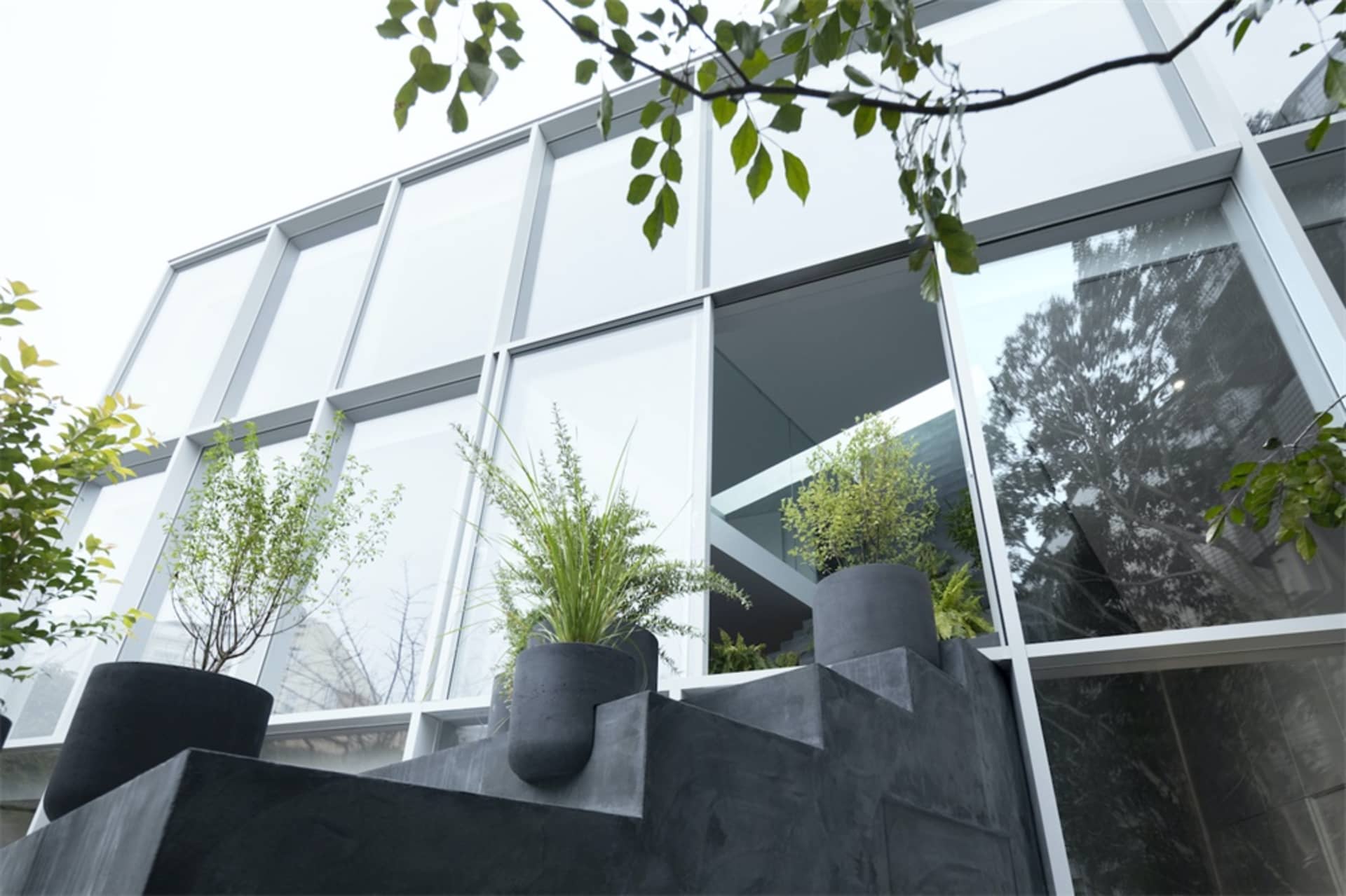 工業風建築前擺放混凝土花盆，種植綠意植物。