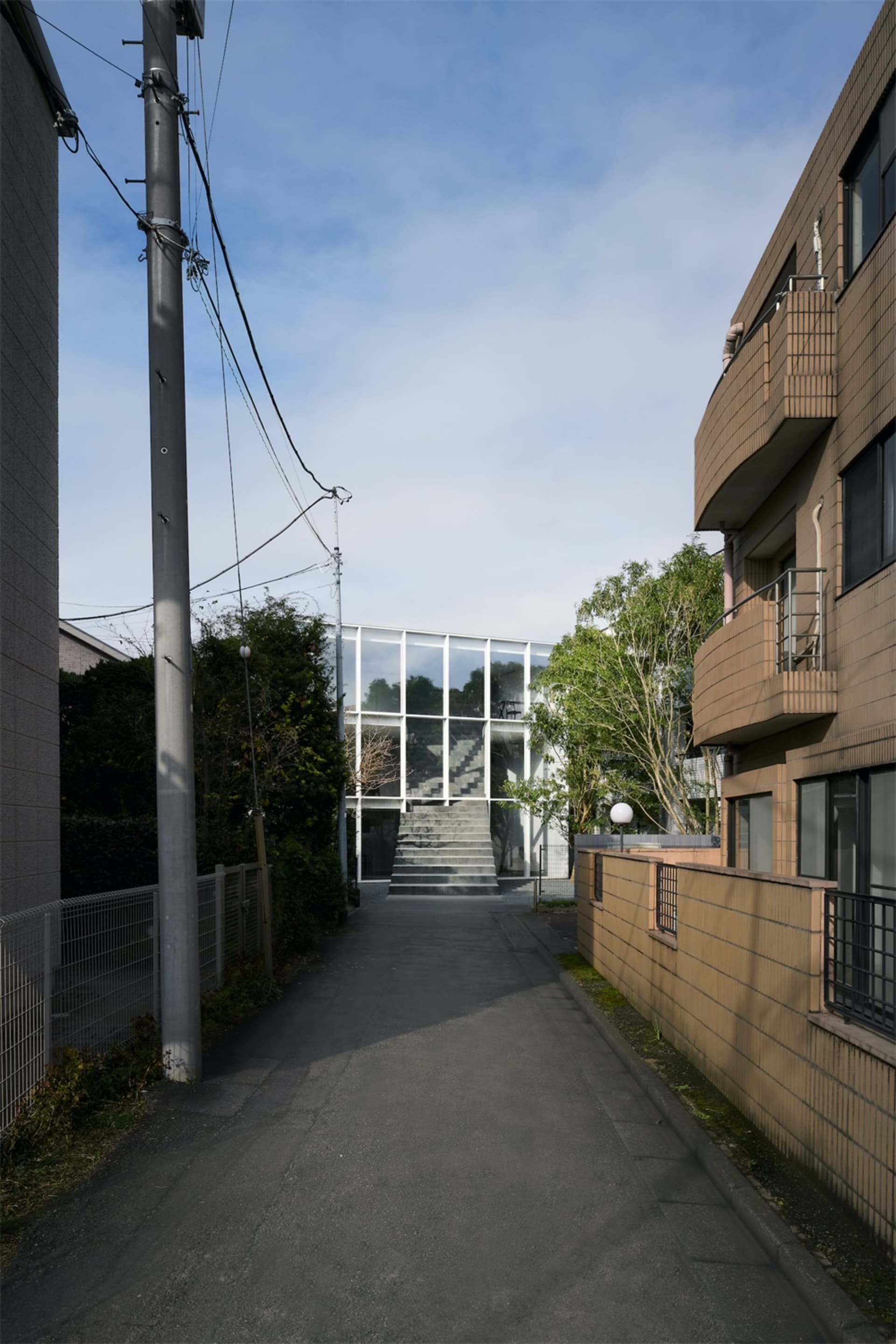 A modern building exterior featuring a combination of aluminum, glass, and concrete materials.