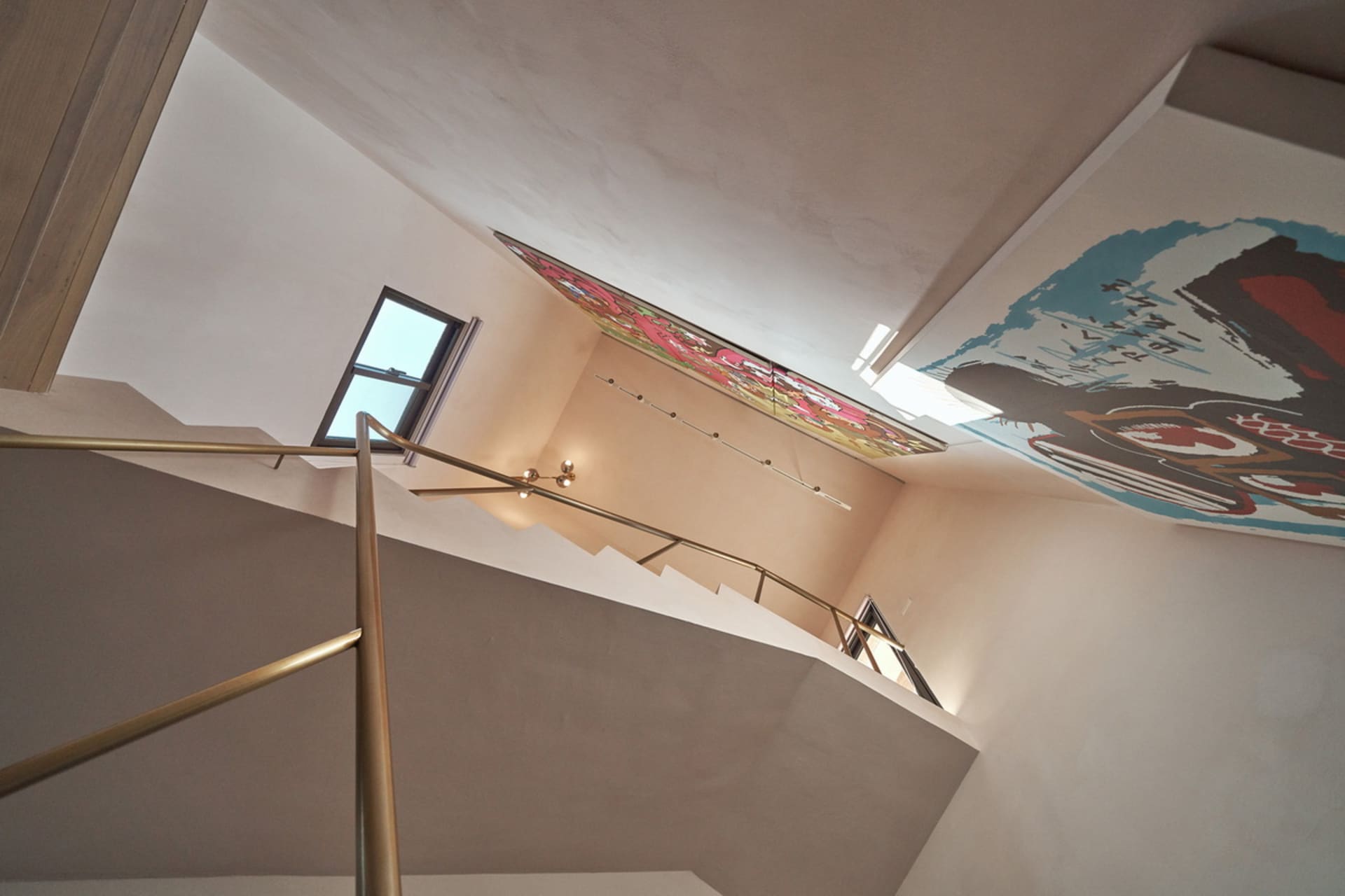 A staircase with a metal handrail and concrete steps set against white walls.