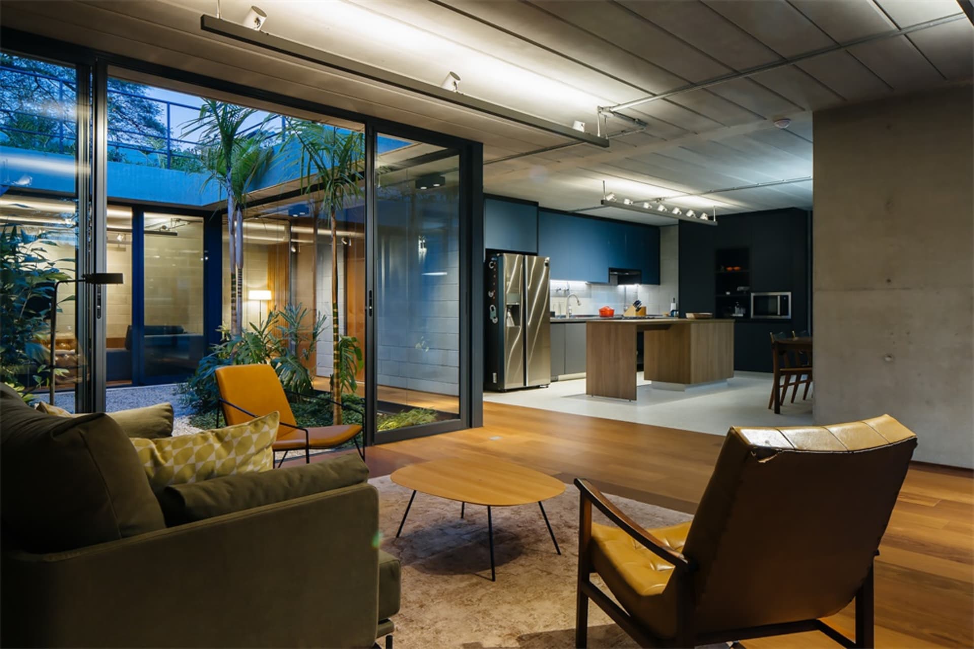 Modern living room with wooden furniture and glass walls.