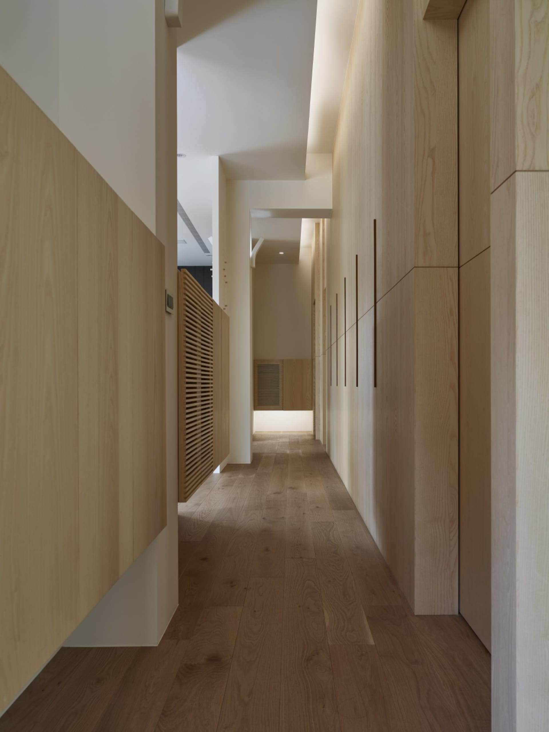 Modern minimalist narrow corridor with wooden flooring and walls.