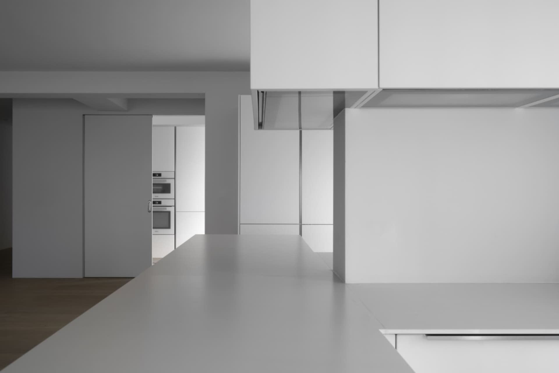 A minimalist kitchen with white cabinets and a clean, uncluttered design.
