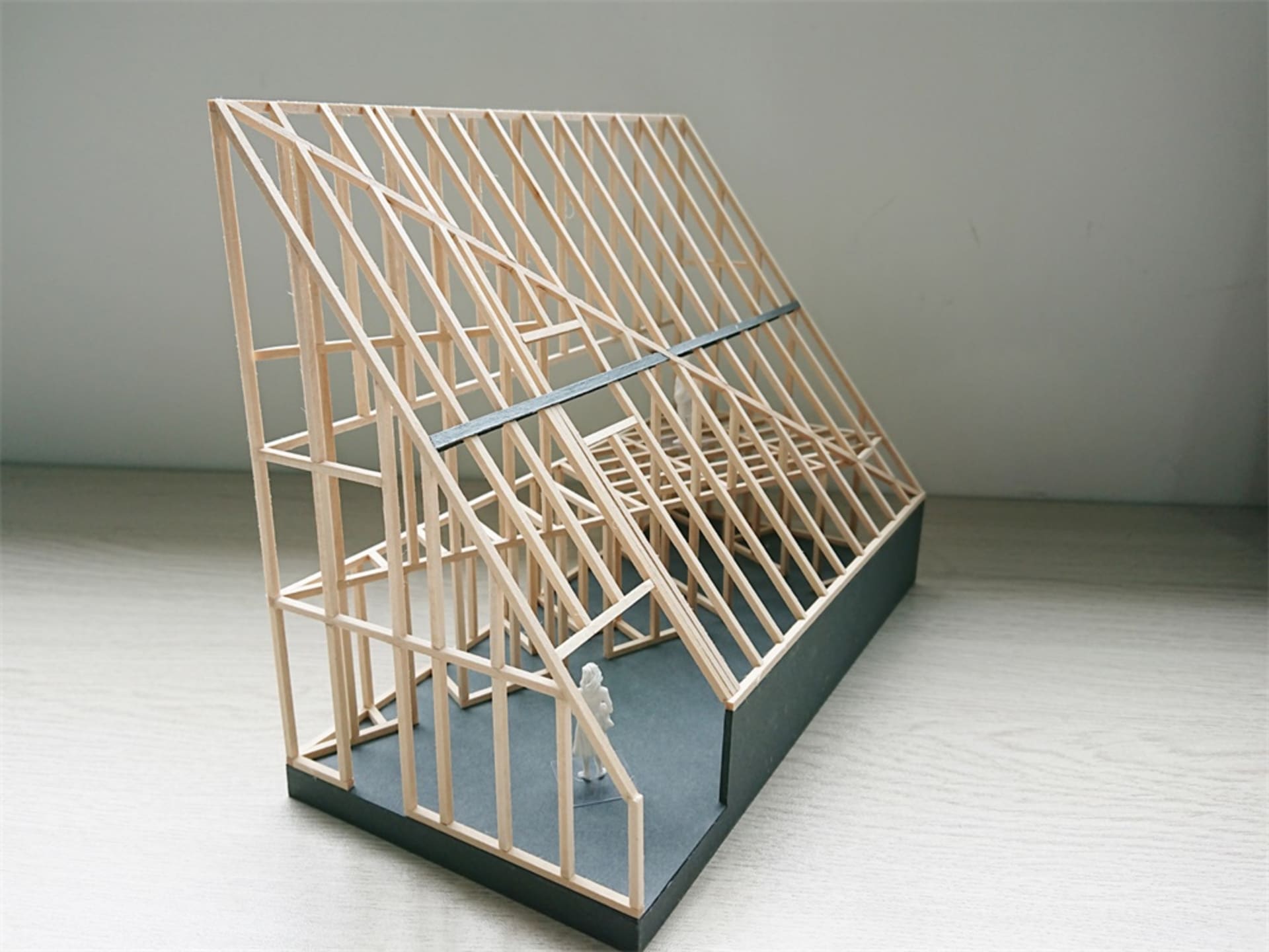 一個木框架結構的3D建築模型，置於灰色底座上。