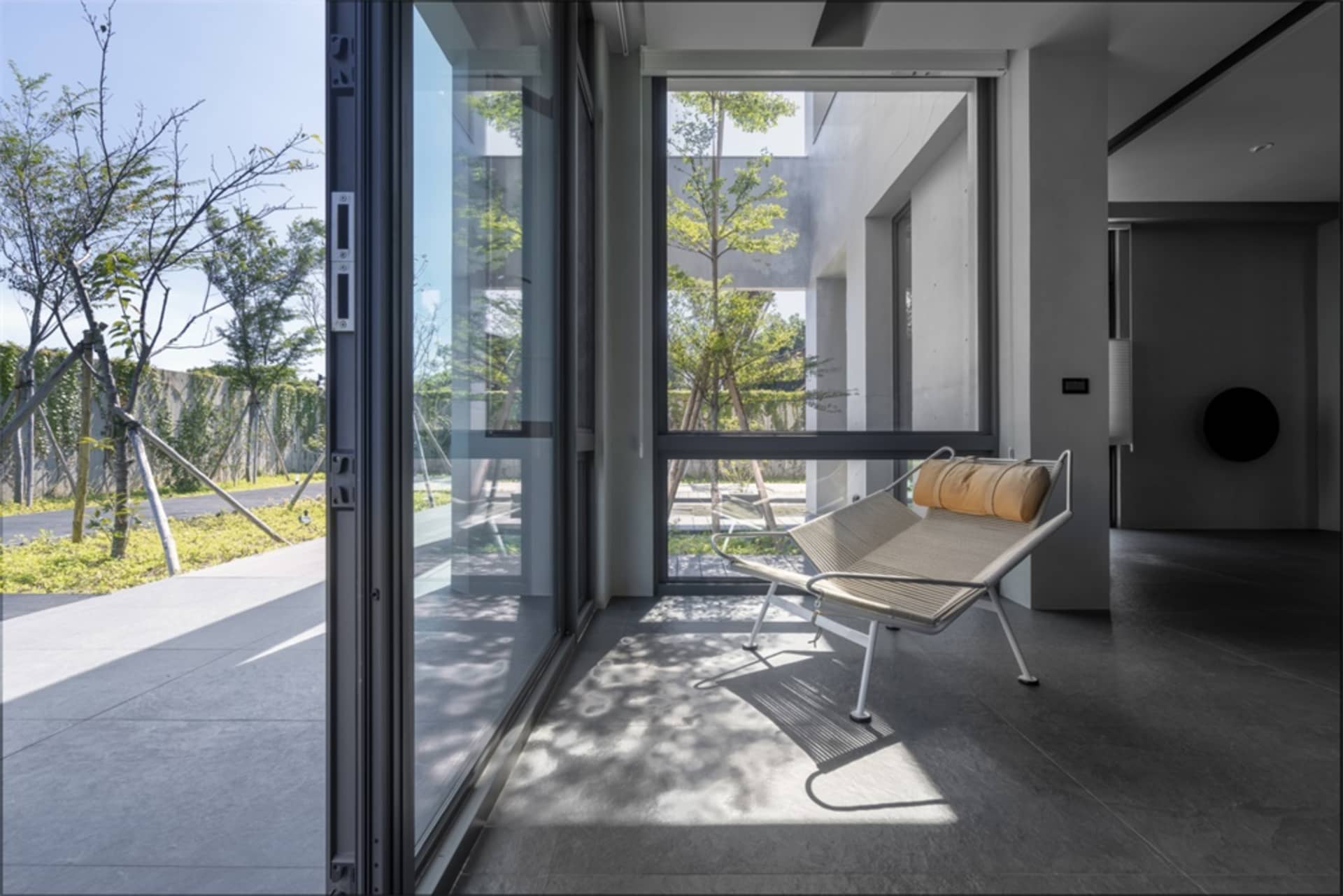 Modern minimalist living room featuring a glass sliding door.