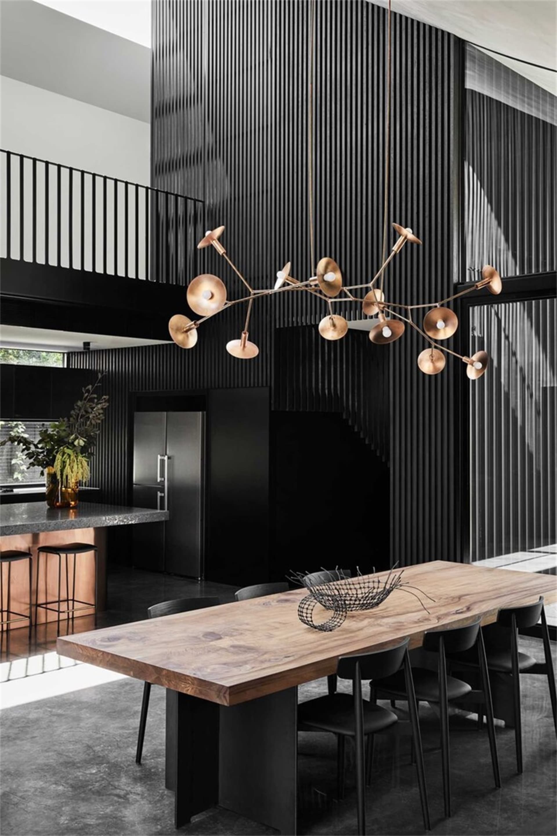 Modern industrial dining space featuring a wooden table and concrete floor.