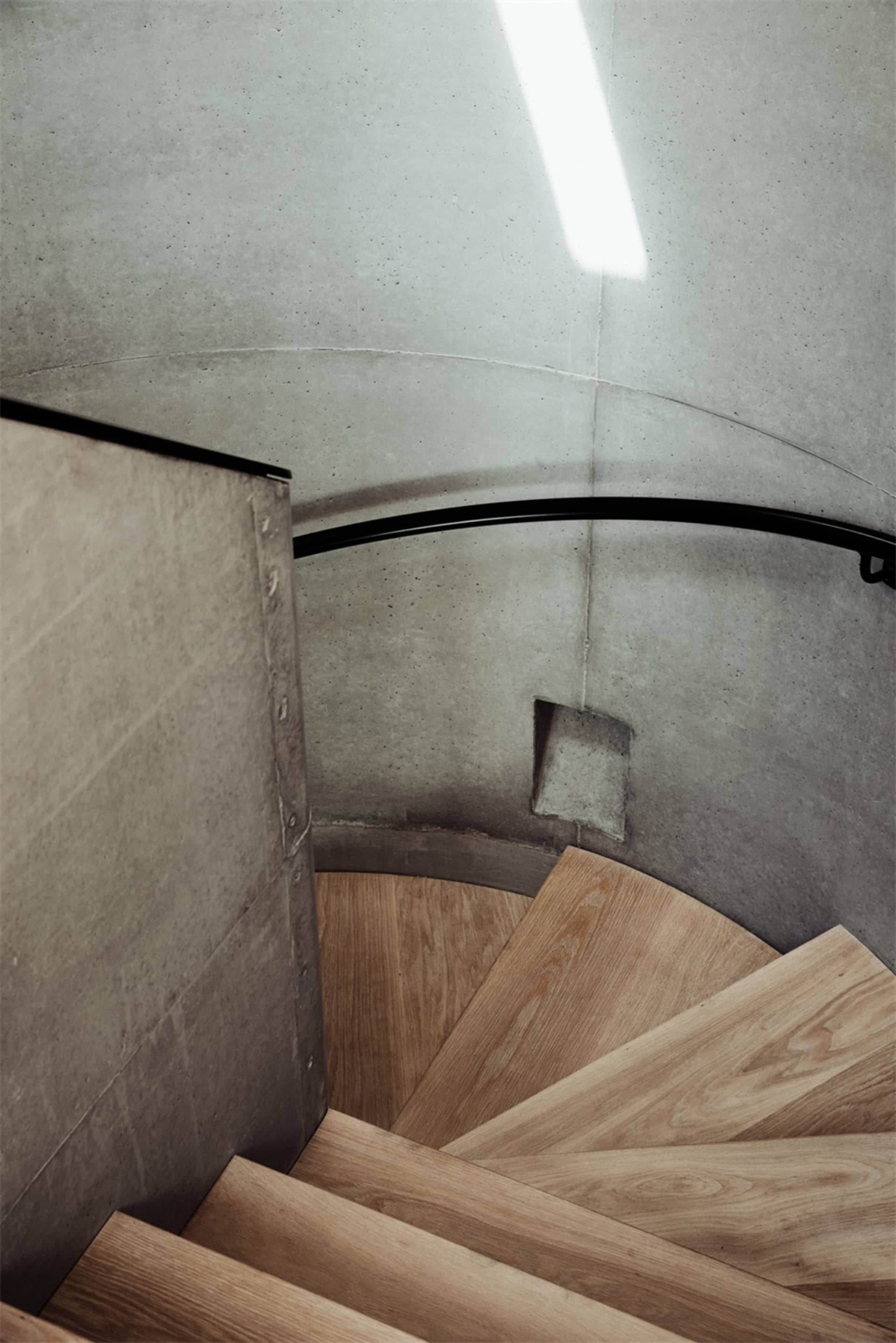 A modern staircase featuring a combination of concrete and wooden steps.