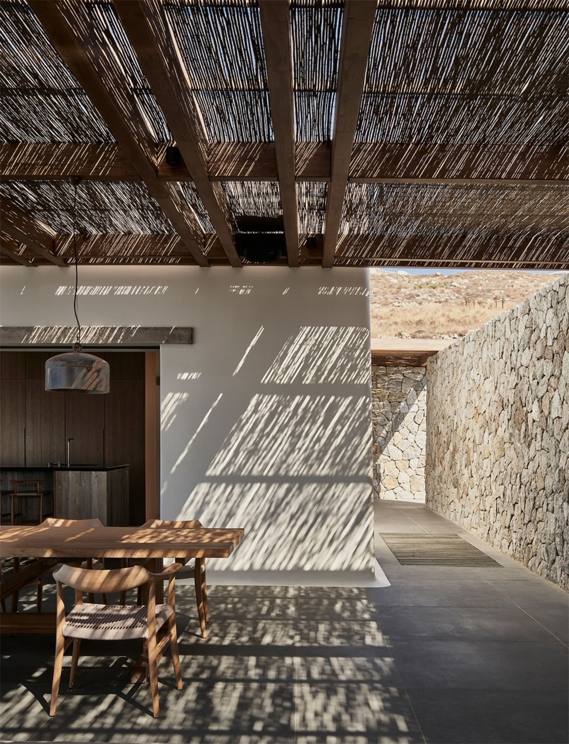 現代住宅庭院，擁有編織天花板與木質餐桌，呈現極簡設計風格
