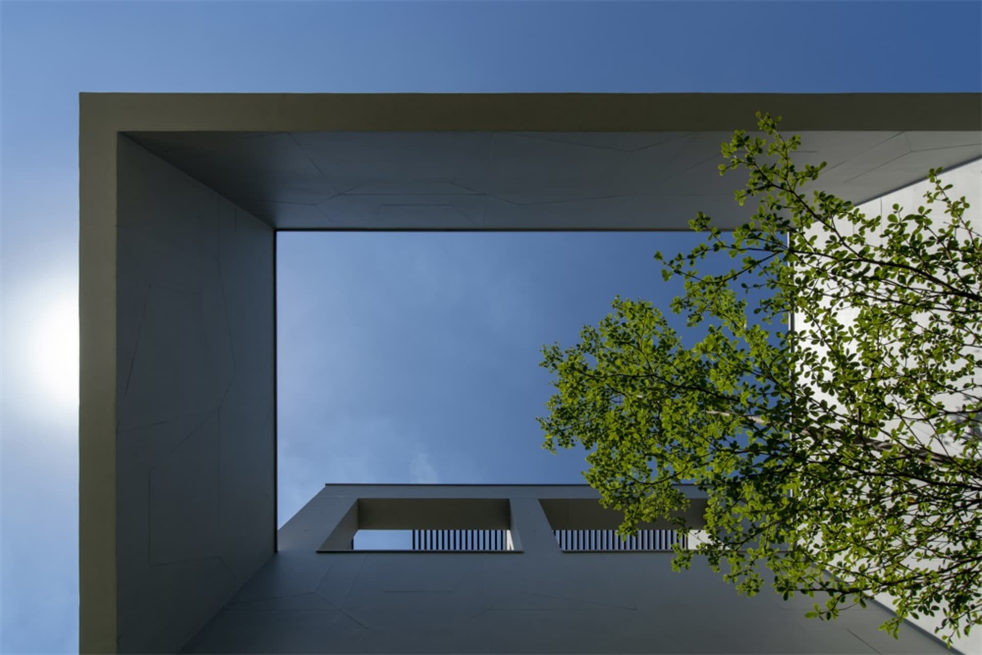 Modern building exterior with concrete material and clear blue sky.