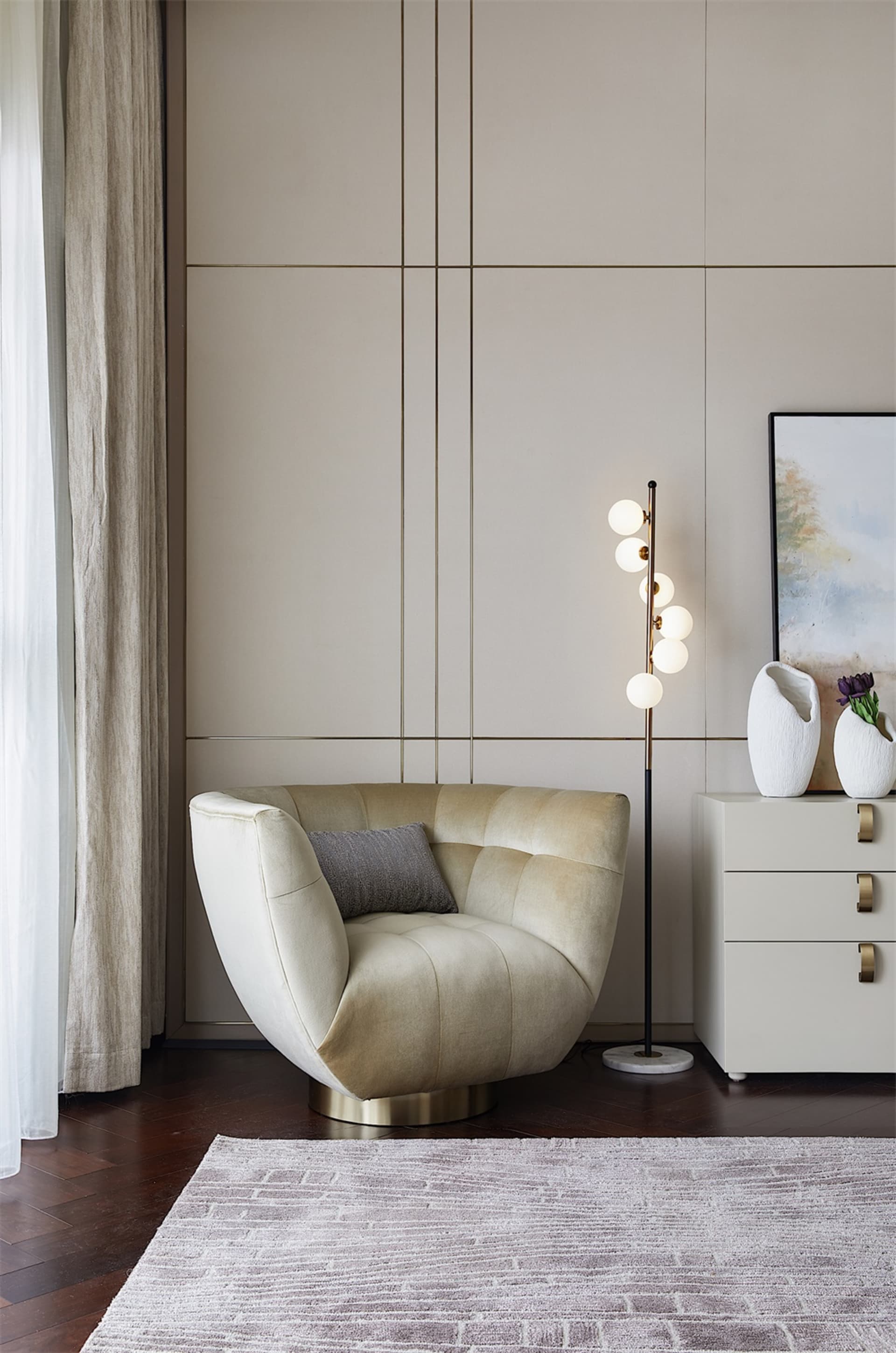 A modern living room with a plush, upholstered armchair, a tall floor lamp with multiple bulbs, and a white side table with d